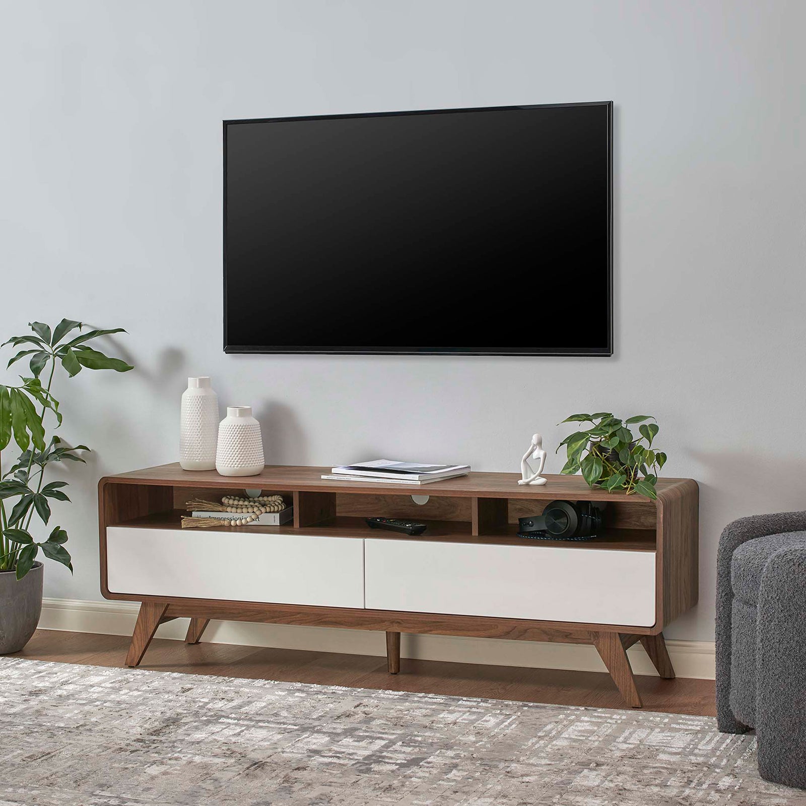 Transmit 60 inch TV stand styled in a modern living room beneath a wall-mounted screen and decor || EEI-6231-WAL-WHI || front_angle_room