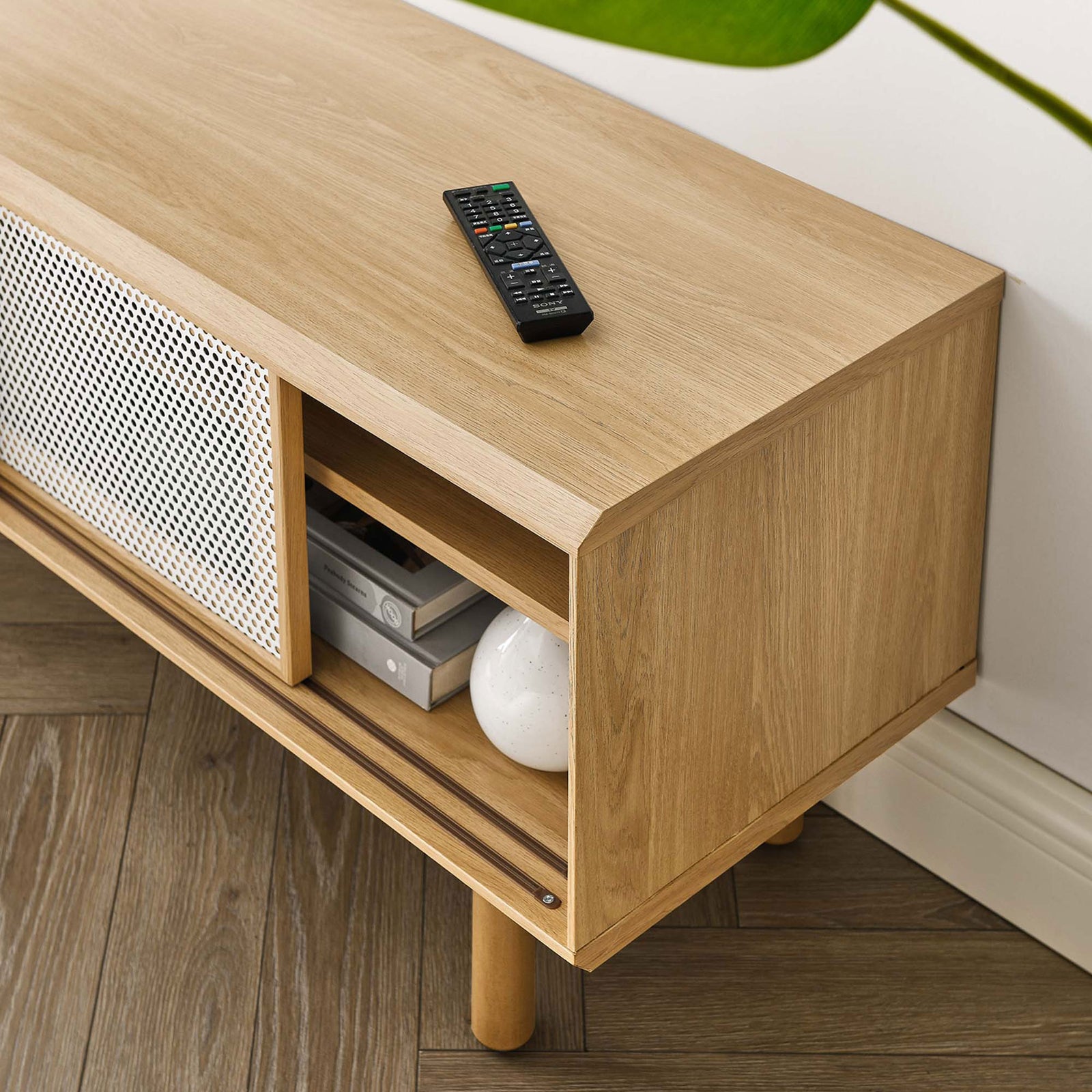 Oak TV stand styled with books and decor, emphasizing warm wood grain and open shelf storage || EEI-6233-OAK || detail_room