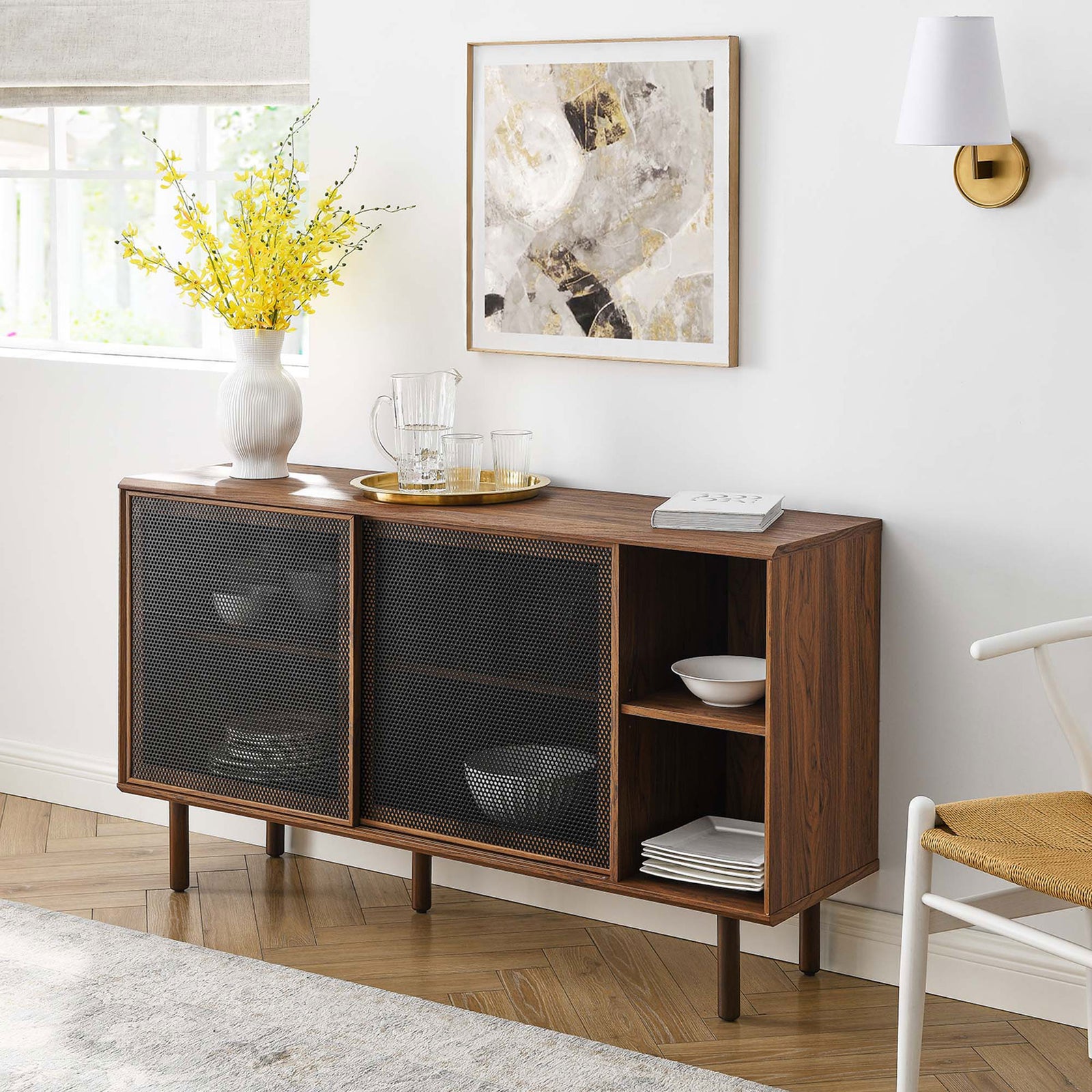 Walnut sideboard with mesh doors styled in a modern dining room with art, lighting, and decor || EEI-6235-WAL || front_angle_room