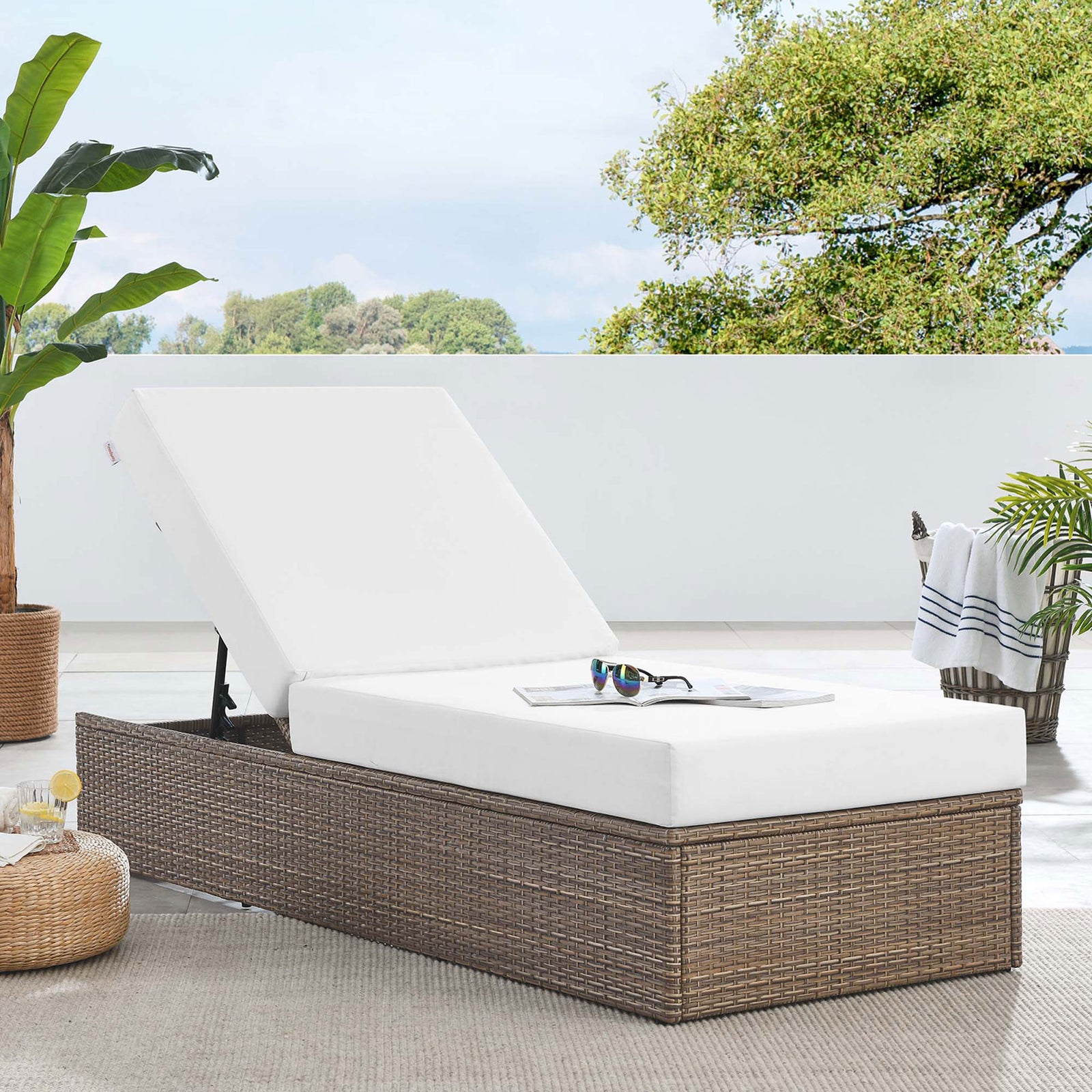 Outdoor wicker chaise lounge with white cushions styled on a sunny terrace for relaxed poolside lounging || EEI-6247-CAP-WHI || front_angle_converted_room