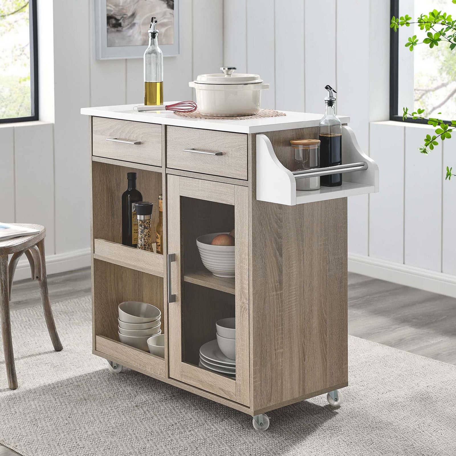 Oak and white kitchen cart styled as a coffee bar with cookware, bottles, and spices in a bright modern dining room || EEI-6277-OAK-WHI || front_angle_room