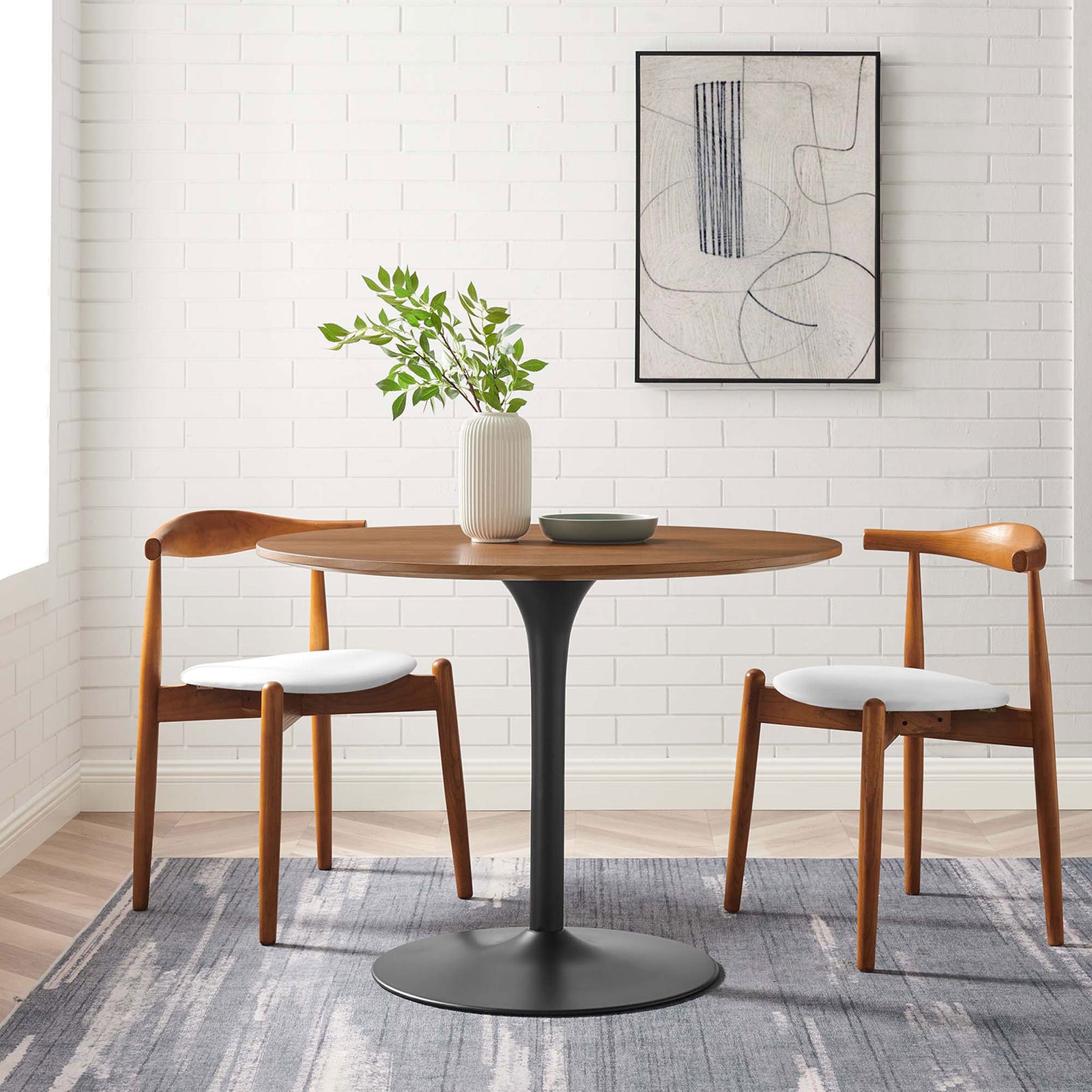 Walnut pedestal dining table with black base styled in a mid century modern dining nook for four. || EEI-6313-WAL-BLK || front_angle_room