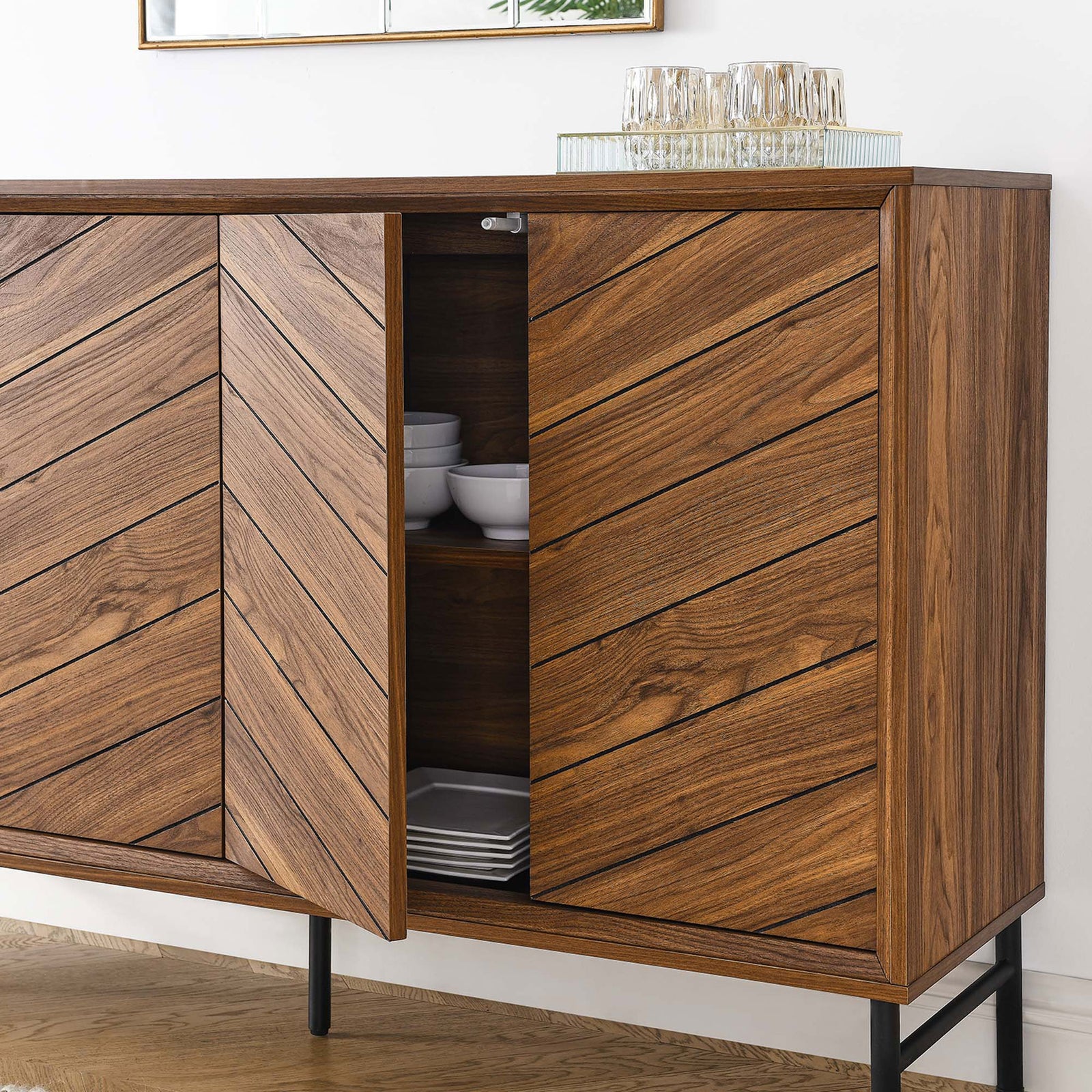 Walnut chevron sideboard styled as a dining buffet with one door open to reveal stacked dishes. || EEI-6336-WAL || front_angle_open_room