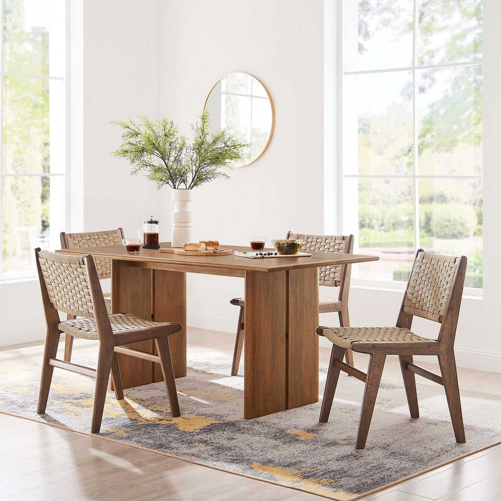 Amistad 60 inch dining table styled in a bright dining room with four woven side chairs || EEI-6338-WAL || front_room