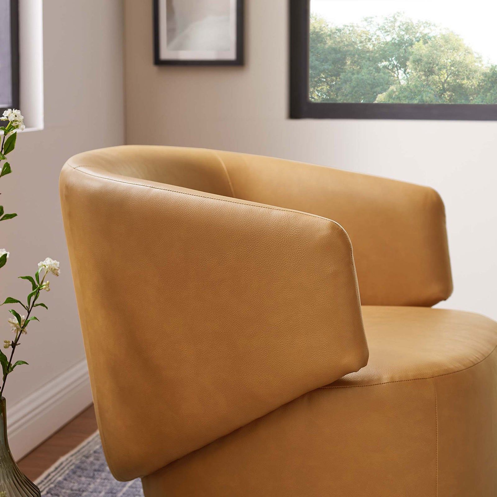 Softly textured vegan leather and crisp tailoring elevate this sculptural swivel accent chair. || EEI-6358-TAN || detail_room