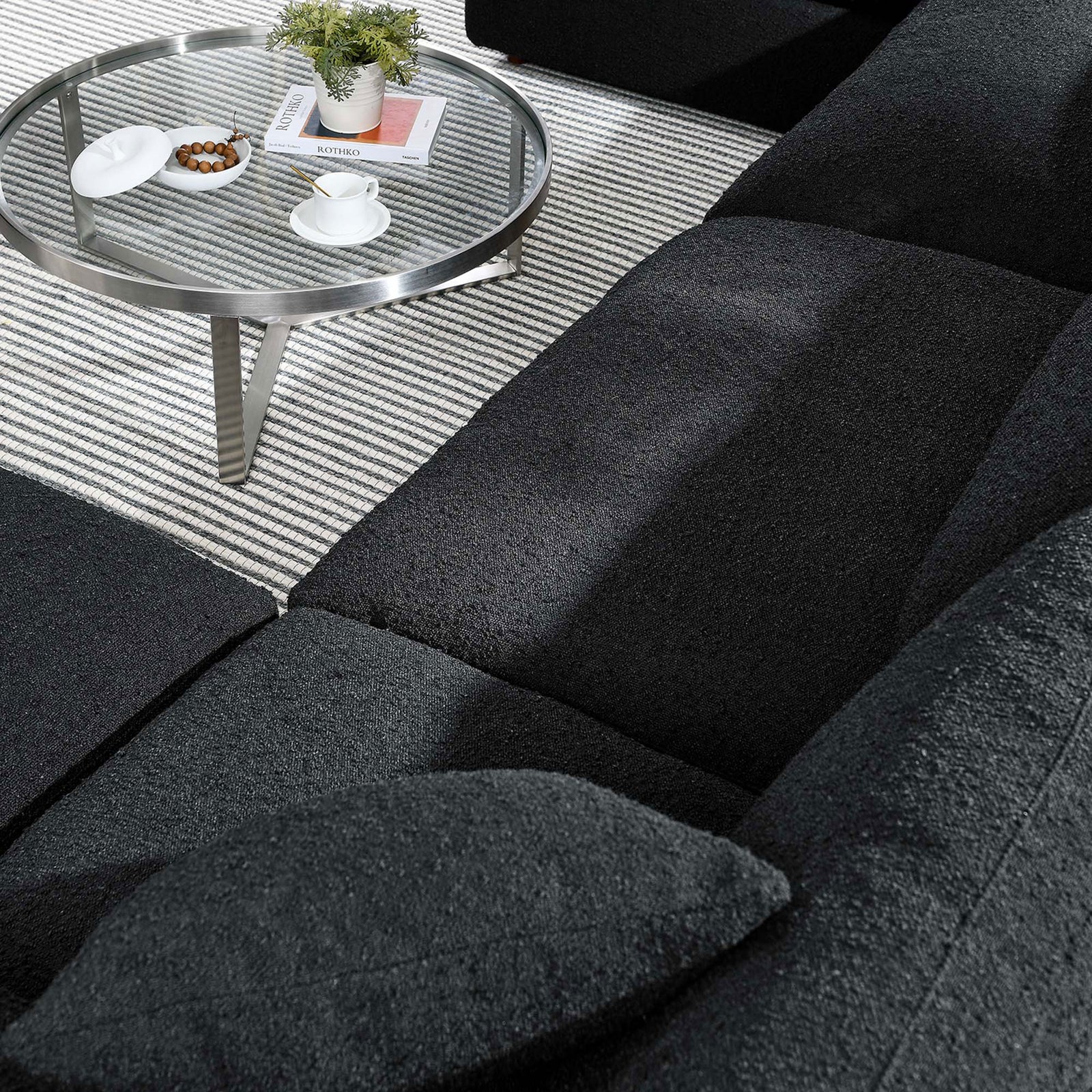 Close-up of black boucle cushions and pillows showcasing the Commix sectional s soft, textured upholstery || EEI-6366-BLK || detail_room