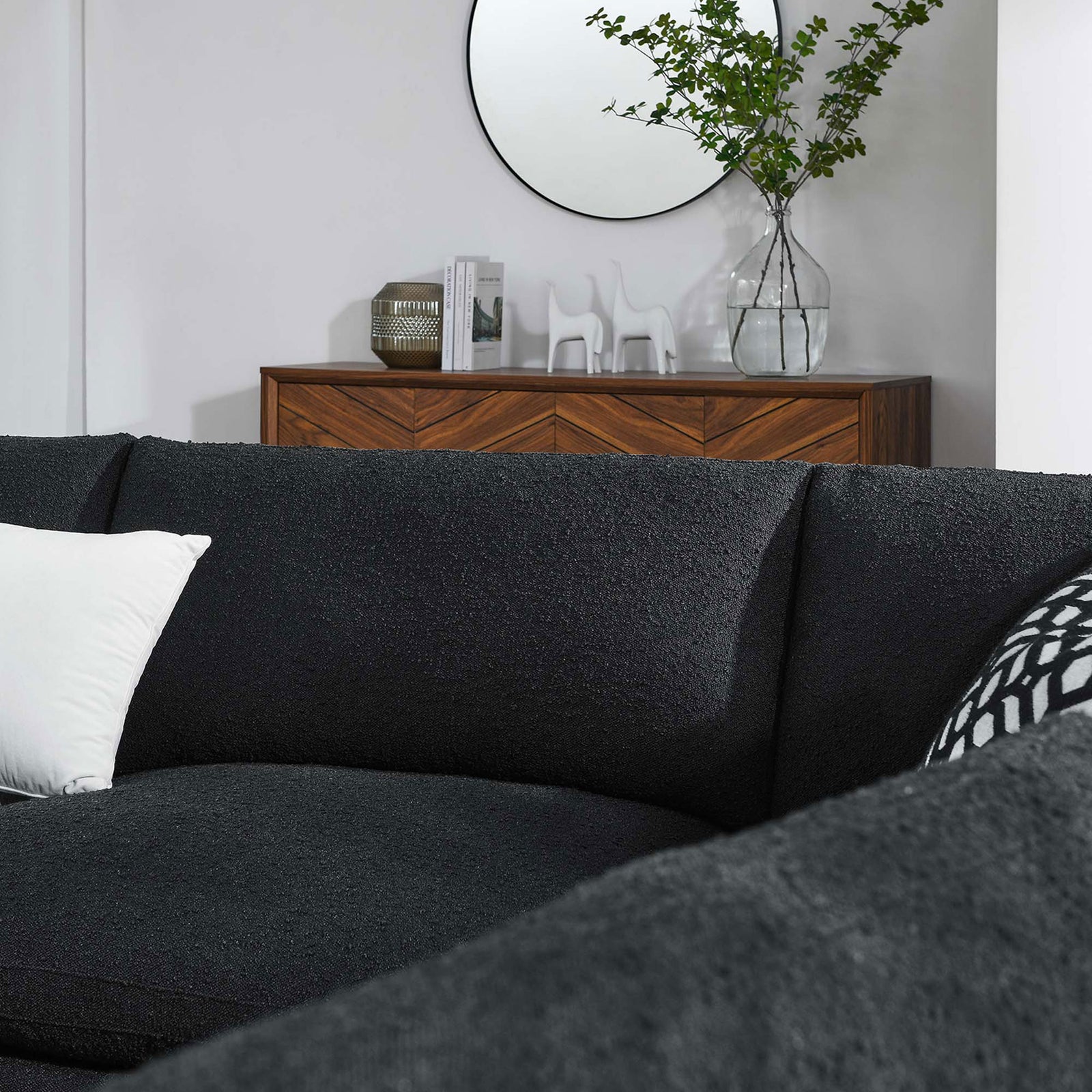 Black boucle sectional cushions styled with patterned and solid pillows in a bright modern living room || EEI-6367-BLK || detail_room