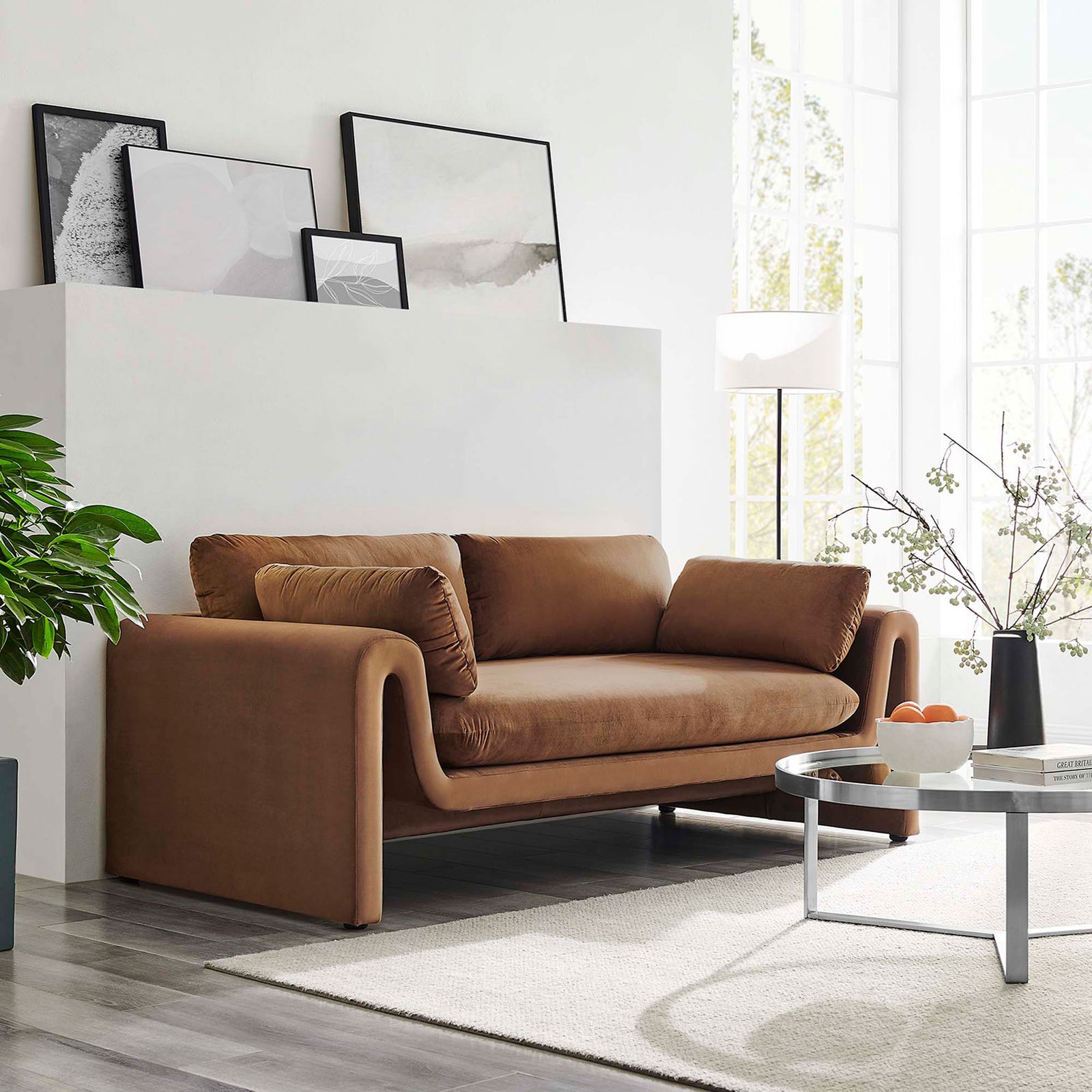 Brown velvet sofa styled in a bright living room, highlighting its flowing curves and cozy cushions || EEI-6382-BRN || front_angle_room