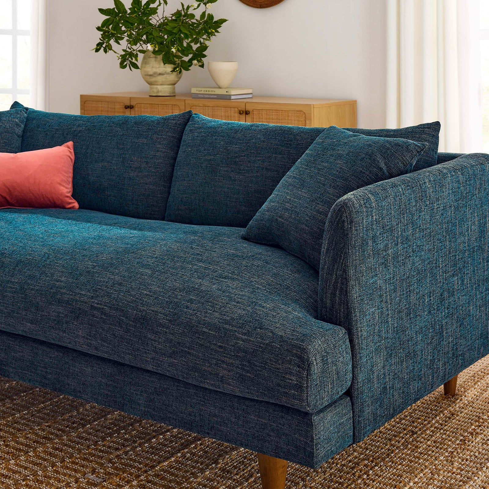 Inviting corner of the Zoya sofa in a bright living room, with textured navy upholstery and cozy accent pillow || EEI-6405-HEA || detail_room