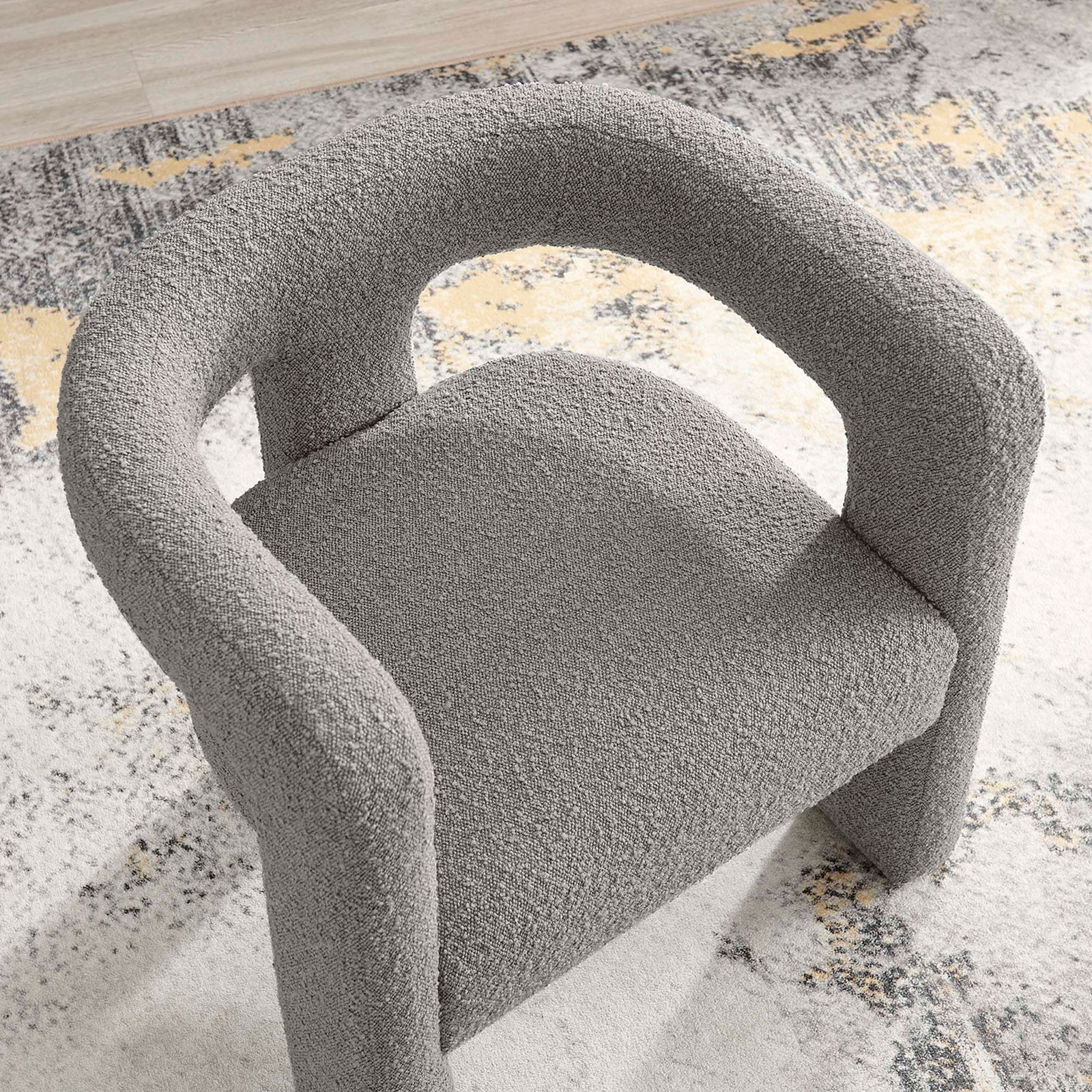 Curved wraparound back and textured boucle seat highlight the chair's sculptural comfort || EEI-6479-LGR || detail_room