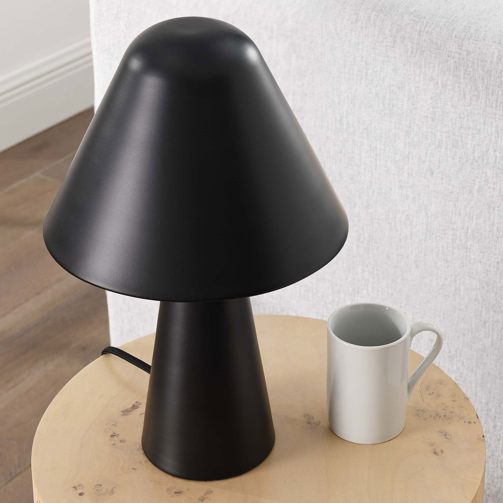 Black Jovial mushroom lamp sits on a wood side table bringing modern charm to the living room. || EEI-6529-BLK || top_angle_room