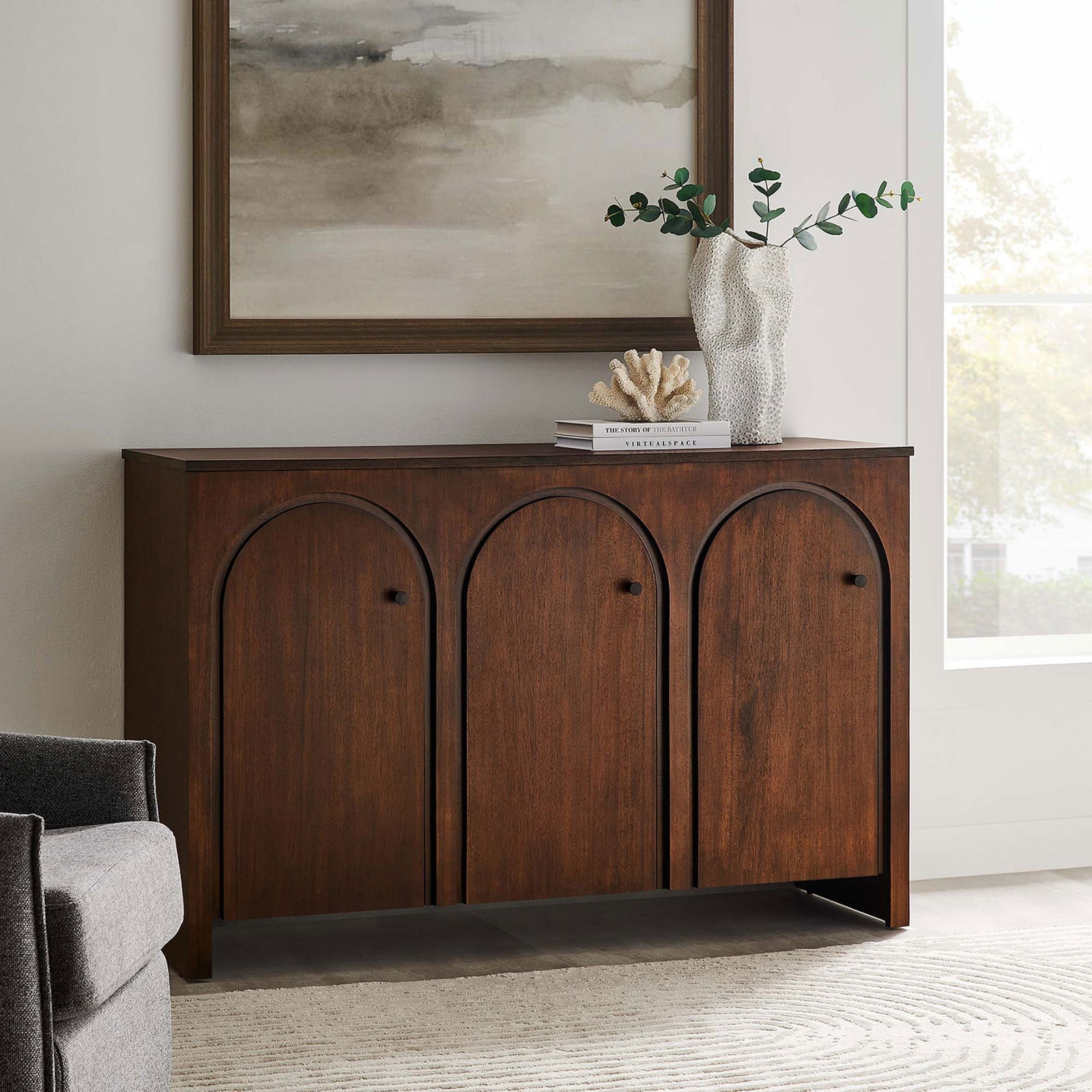 Walnut Appia sideboard styled in a bright living room with decor, artwork, and a neutral rug. || EEI-6536-WAL || front_angle_room