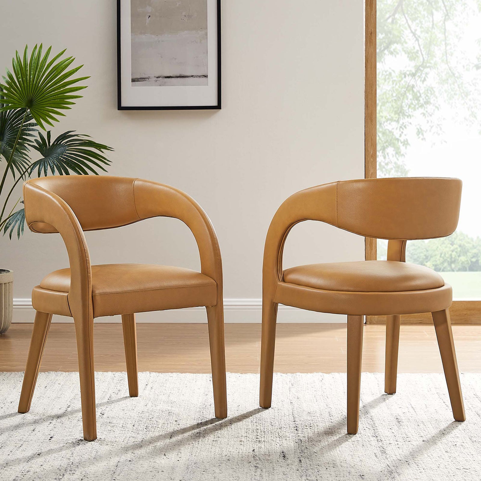 Pair of tan vegan leather dining chairs styled in a bright modern dining space || EEI-6561-TAN || front_angle_multi_room