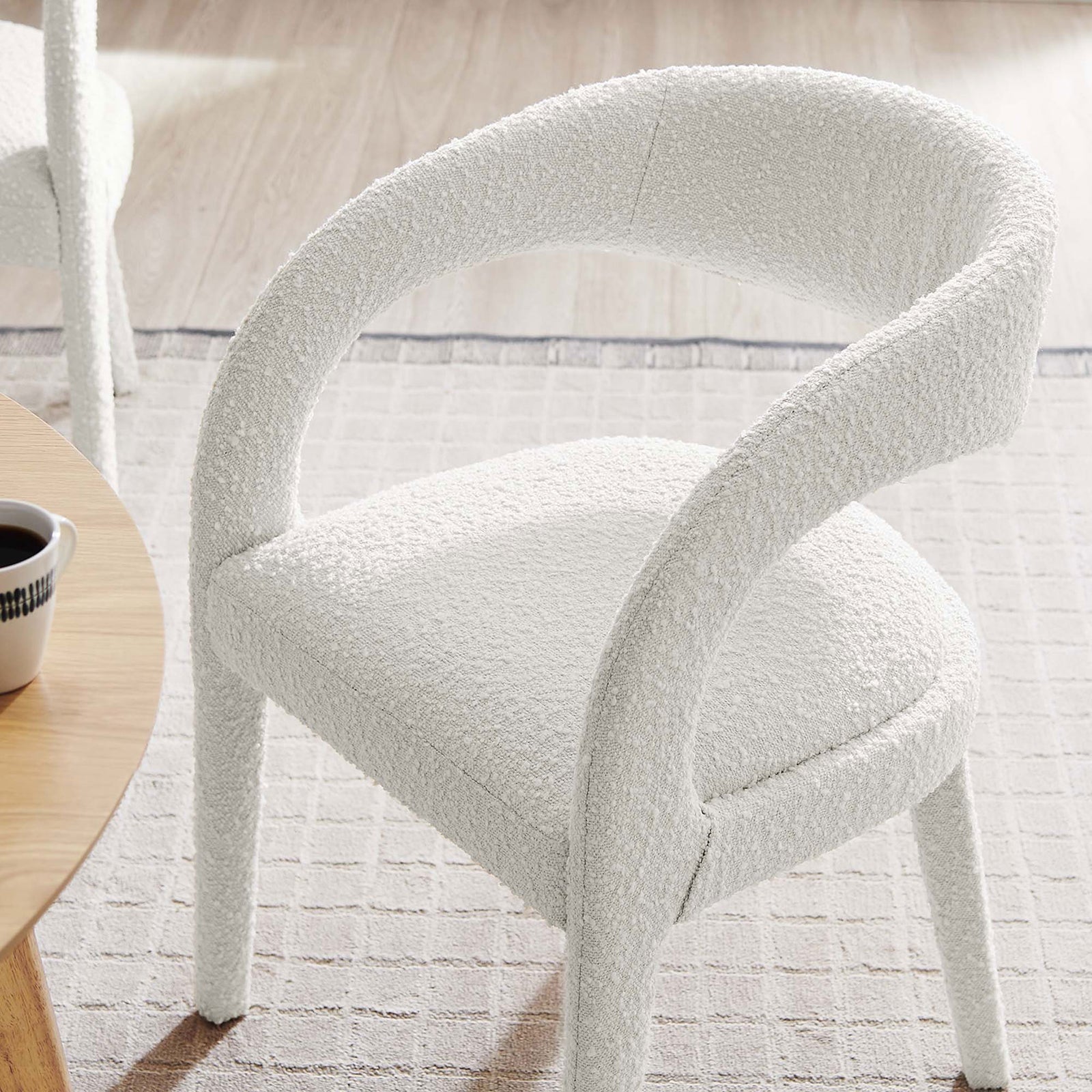 Ivory boucle dining chair styled in a bright dining space beside a wooden table and neutral rug. || EEI-6562-IVO || front_angle_room