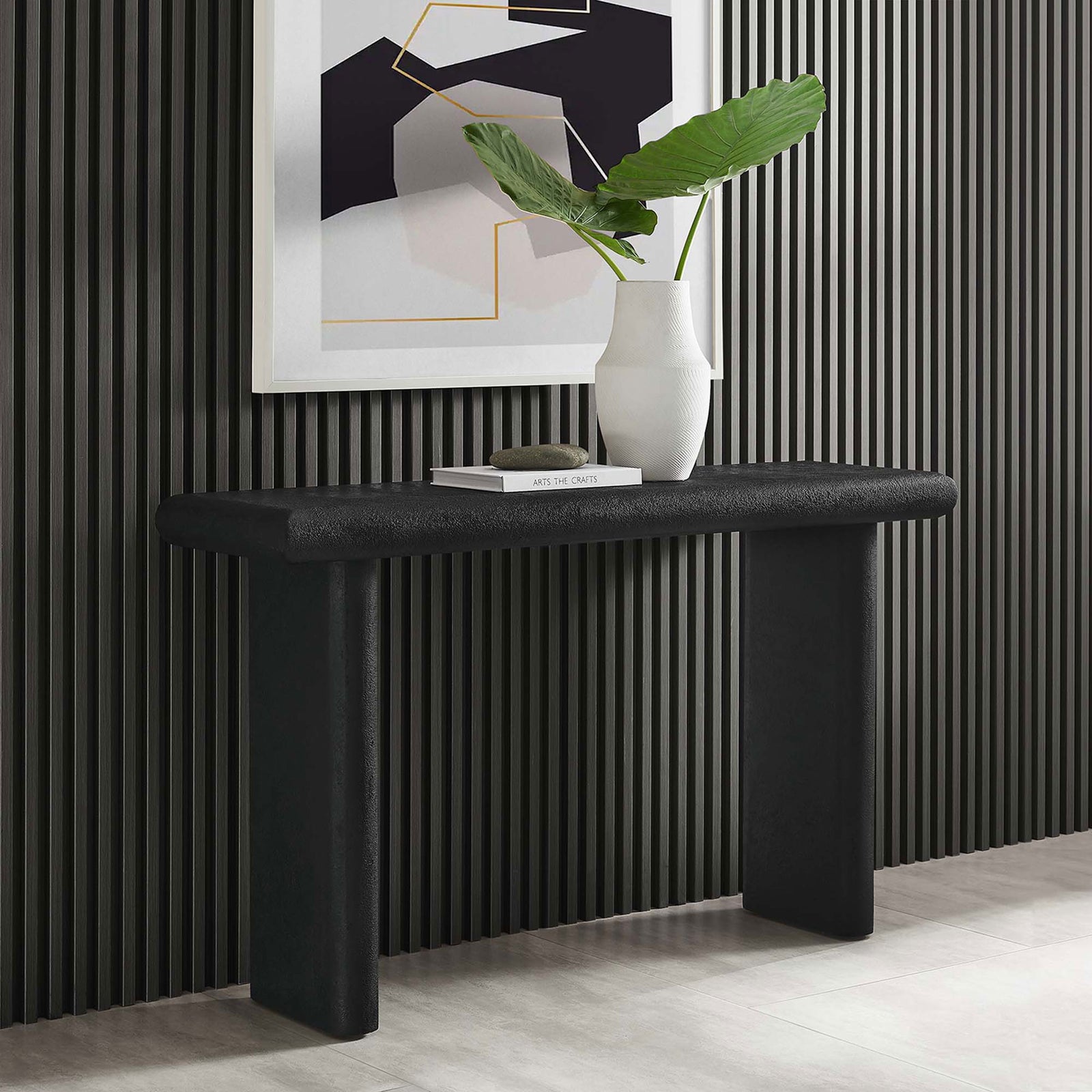 Modern black console grounds an entry with its sculptural silhouette and softly rounded edges || EEI-6577-BLK || front_angle_room