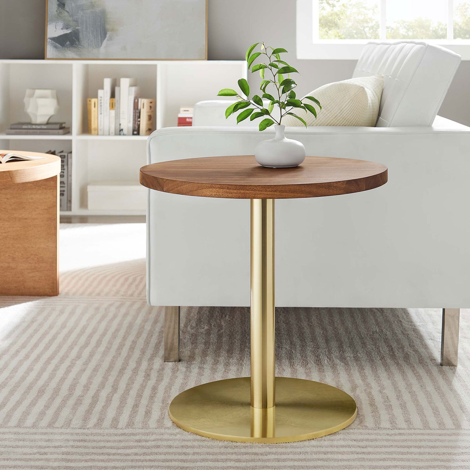 Viva round acacia wood side table with brass pedestal base styled next to a modern white sofa || EEI-6610-BRA-LOC || front_room
