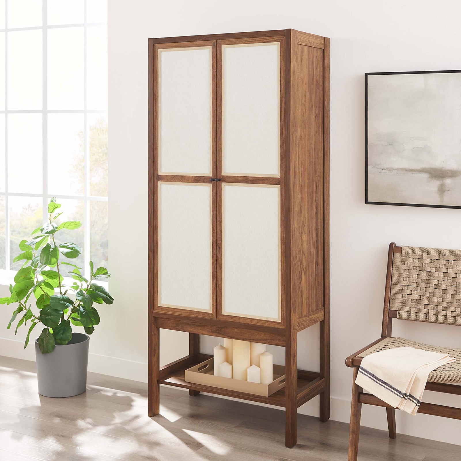 Capri tall cabinet styled in a bright room with candles on the lower shelf for warm, modern storage || EEI-6620-WAL || front_angle_room