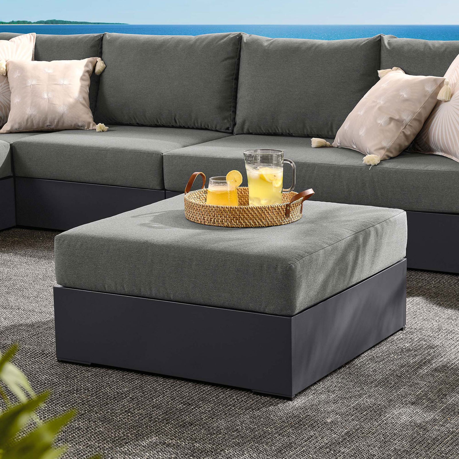 Tahoe charcoal ottoman doubles as a coffee table in a coordinated outdoor sectional seating area || EEI-6627-GRY-CHA || front_angle_room