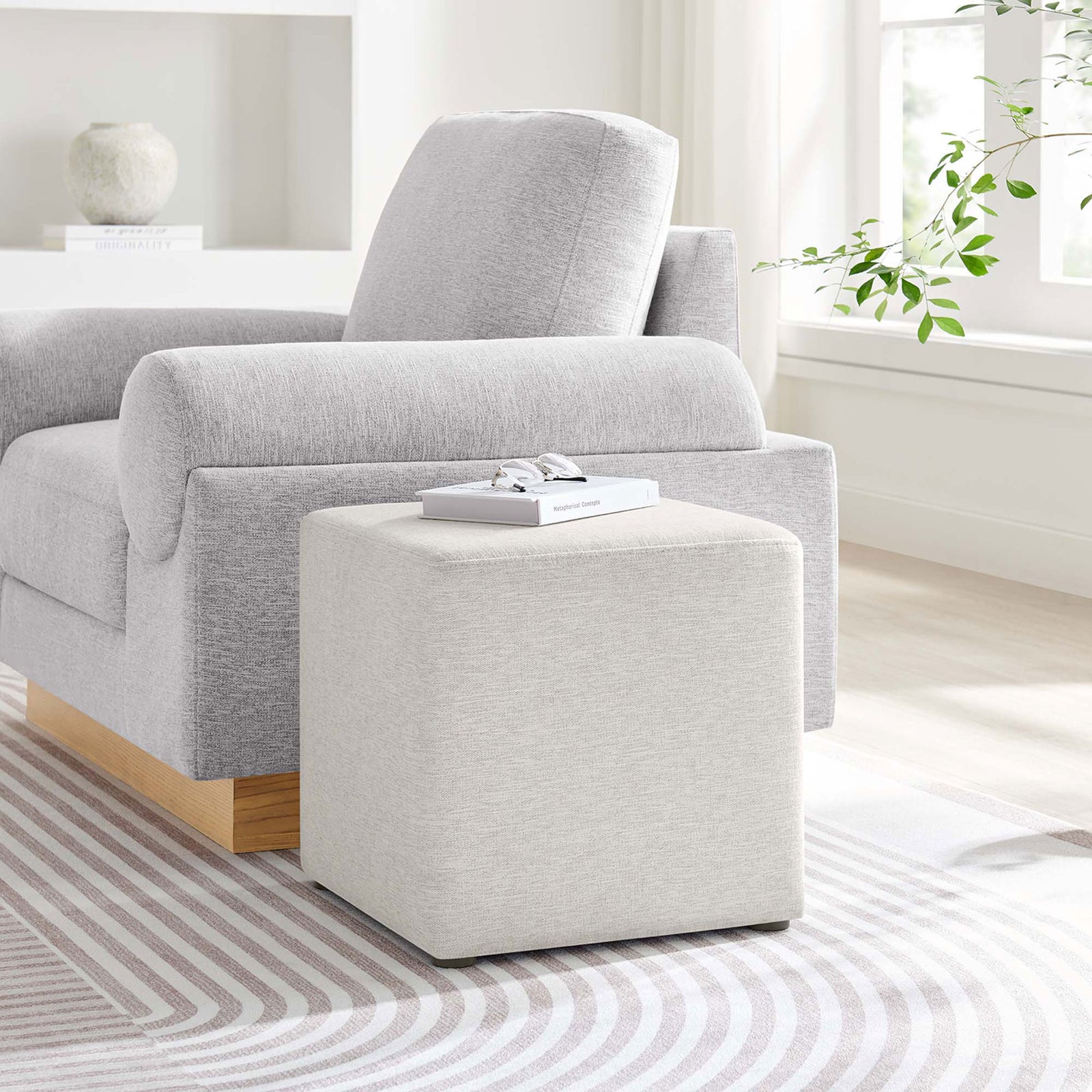 Ivory cube ottoman paired with a modern sofa, adding a versatile accent seat or footrest to the living room. || EEI-6636-HEI || front_angle_room