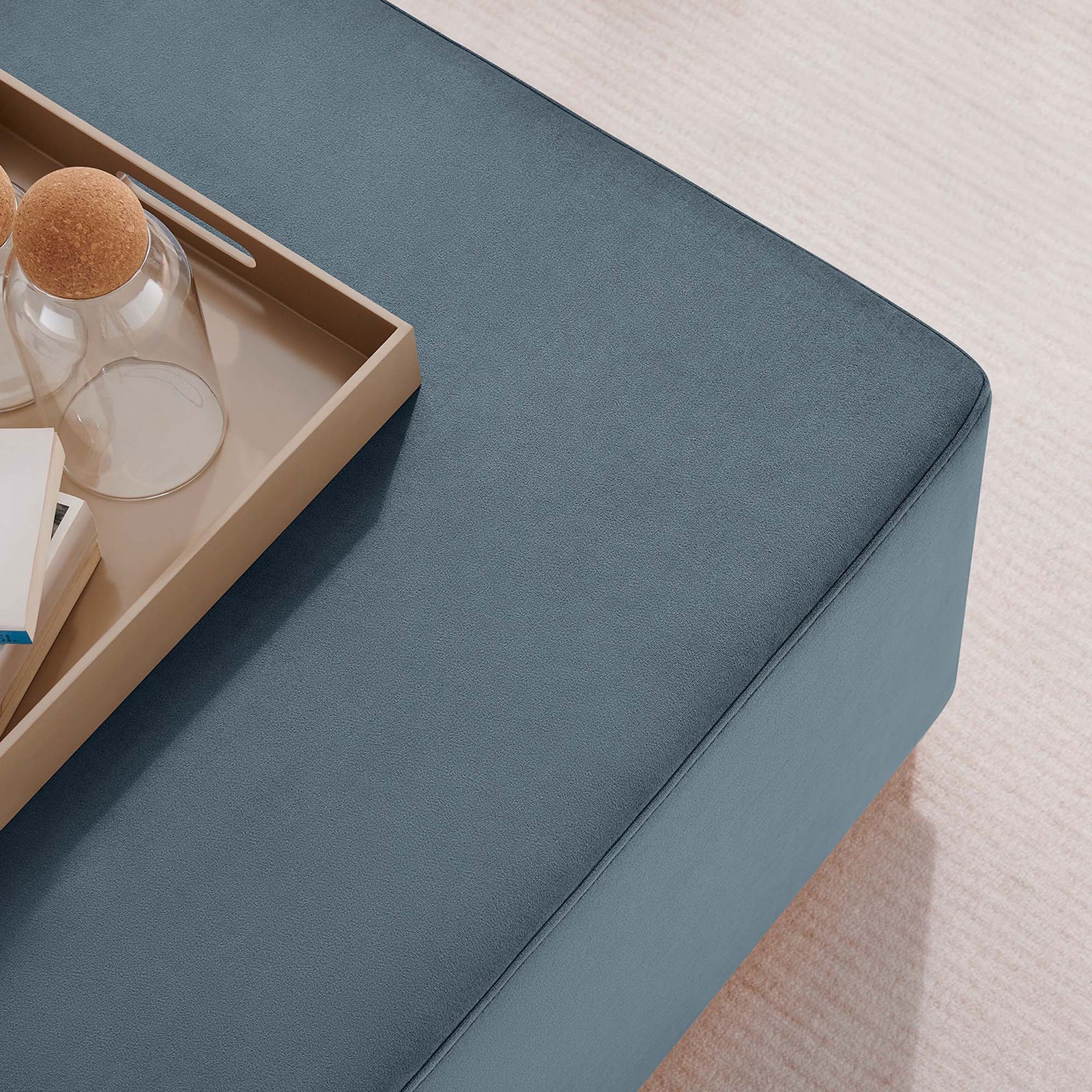 Velvet ottoman doubles as a chic coffee table with tray, glasses, and books in a cozy living room || EEI-6643-CAB-NAT || detail_room