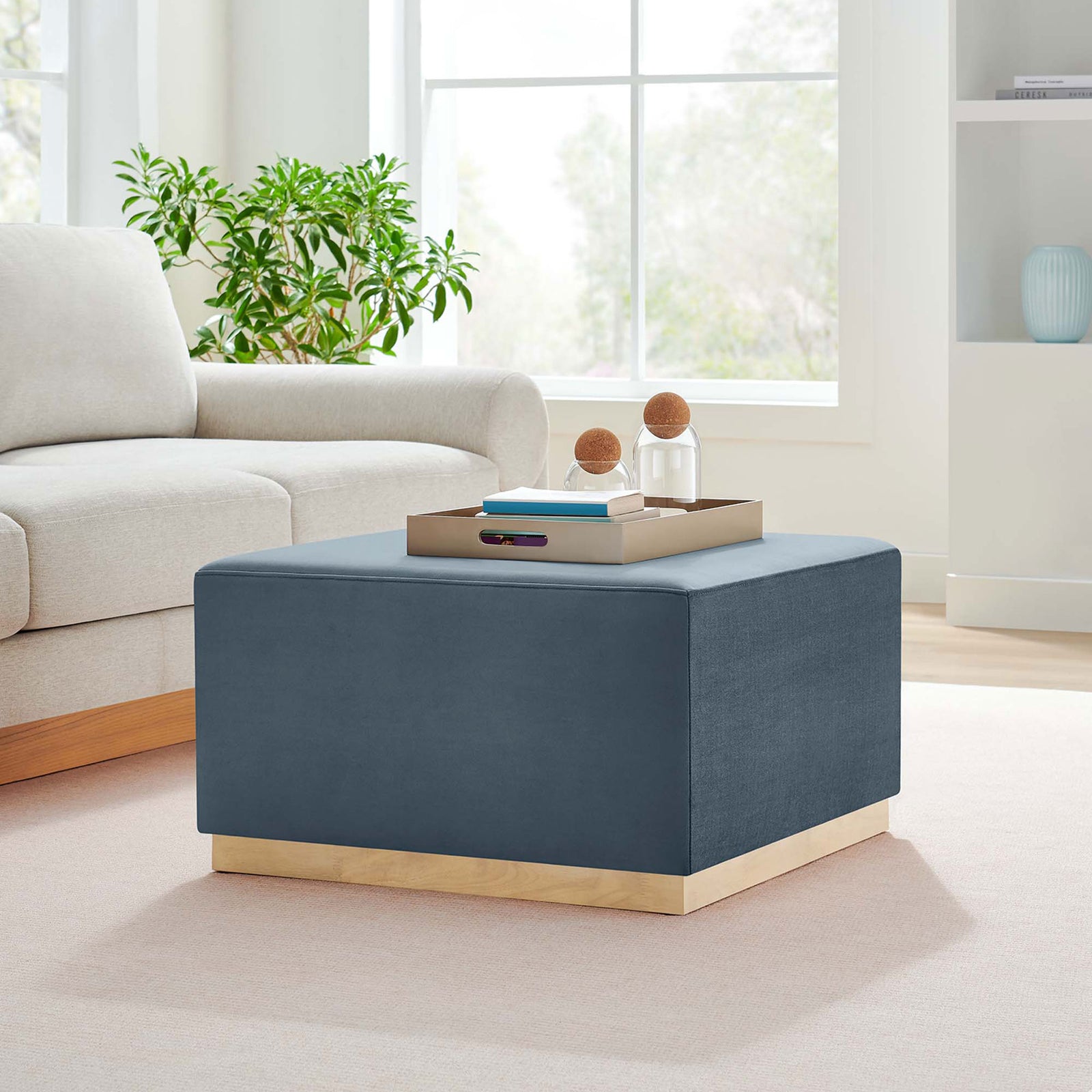 Cadet blue velvet ottoman anchors the living room as a soft coffee table beside a light modern sofa || EEI-6643-CAB-NAT || front_angle_room