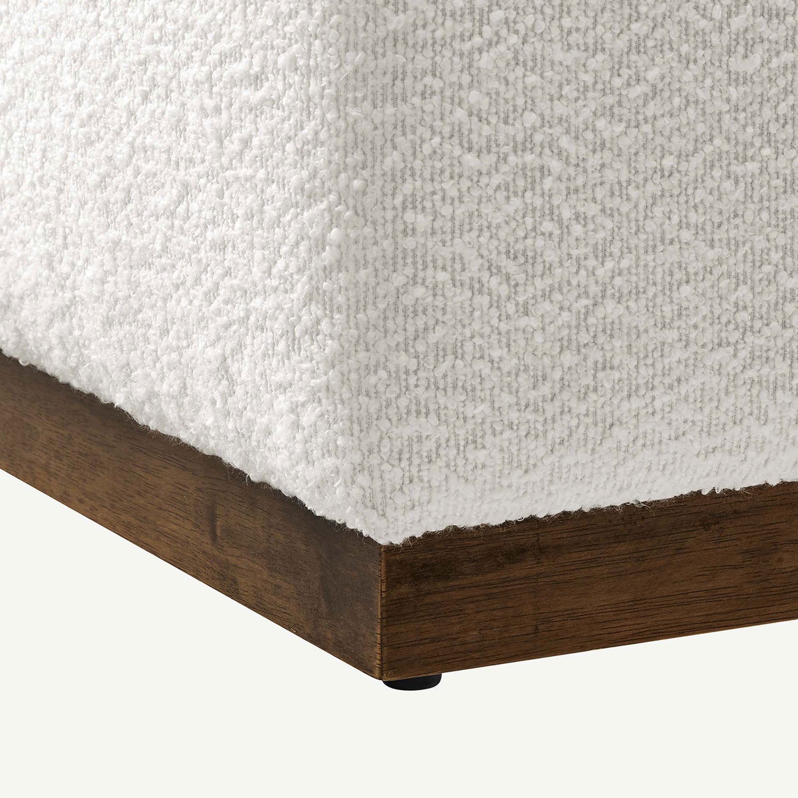 Nubby boucle texture wraps the ottoman corner above a smooth walnut plinth base and glide. || EEI-6644-CLO-WAL || detail_studio