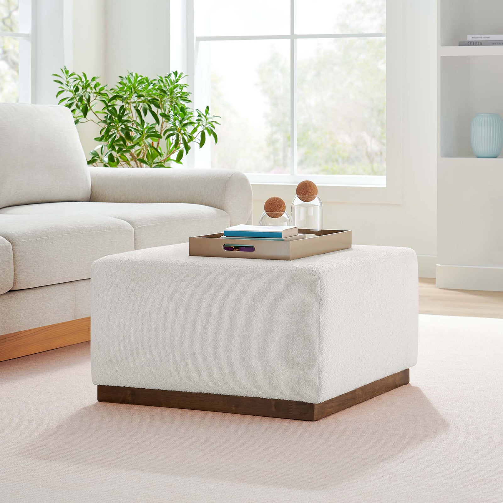 Cloud boucle ottoman anchors an airy living room as a modern coffee table and extra seating. || EEI-6644-CLO-WAL || front_angle_room