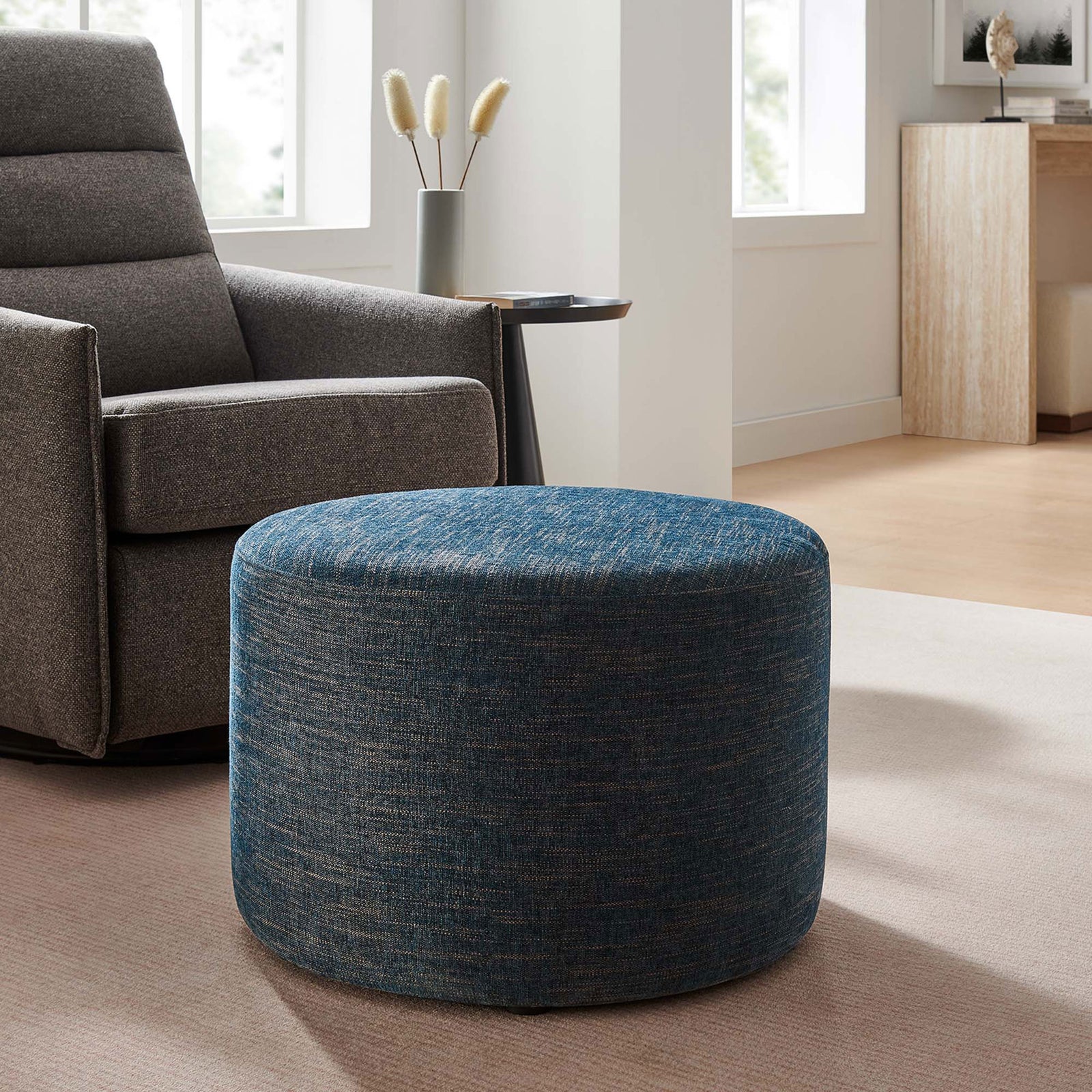 Azure fabric ottoman complements modern seating, offering a soft landing spot in a cozy lounge corner || EEI-6645-HEA || front_angle_room