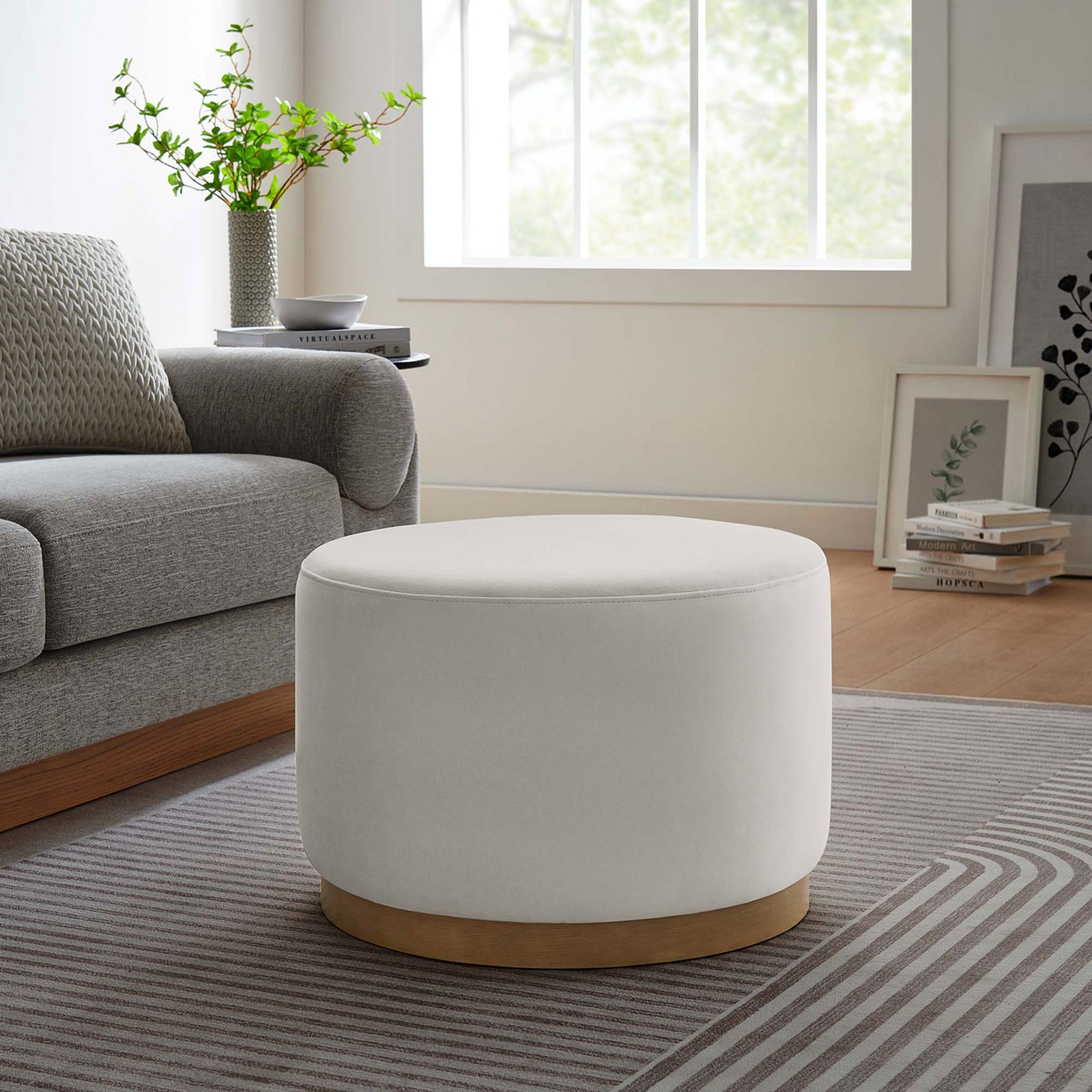 Alabaster ottoman pairs with a gray sofa and patterned rug to bring soft contrast to a cozy lounge. || EEI-6646-ALA-NAT || front_room