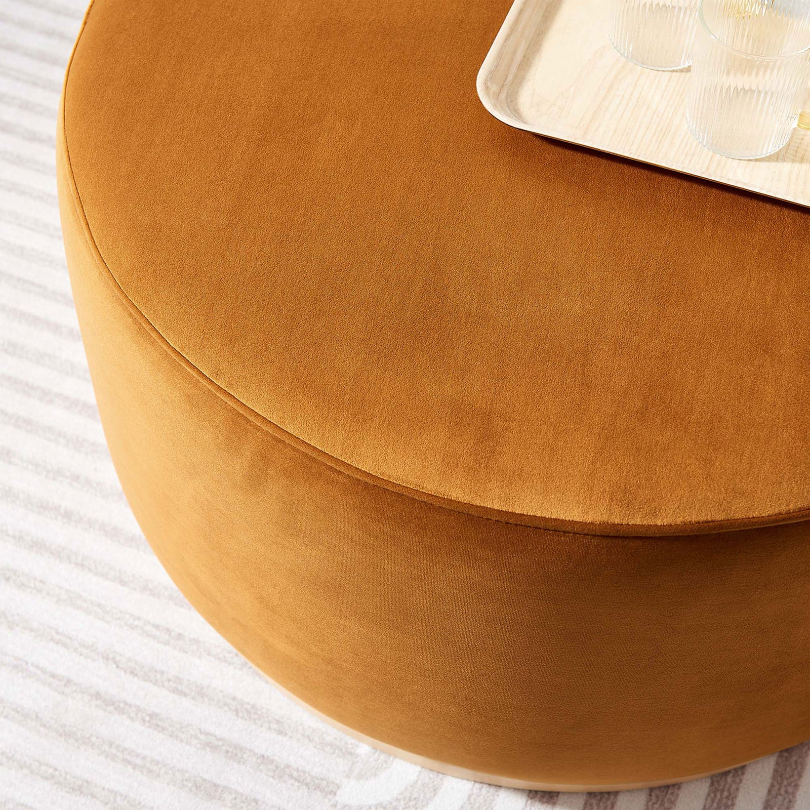 Rust velvet ottoman topped with tray and glasses, serving as a soft coffee table in living room. || EEI-6648-RUS-NAT || detail_room