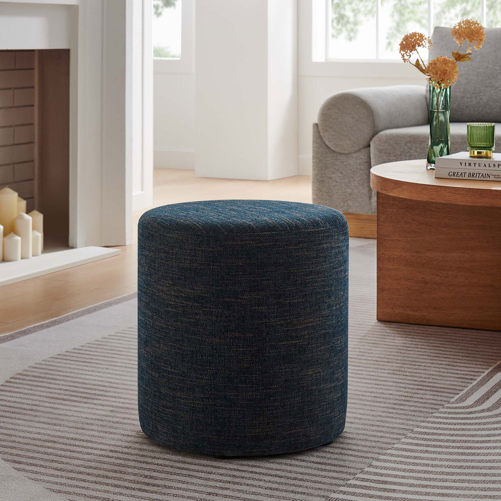 Round azure ottoman completes a modern seating area, offering versatile use as a seat, table, or footrest || EEI-6651-HEA || front_angle_room