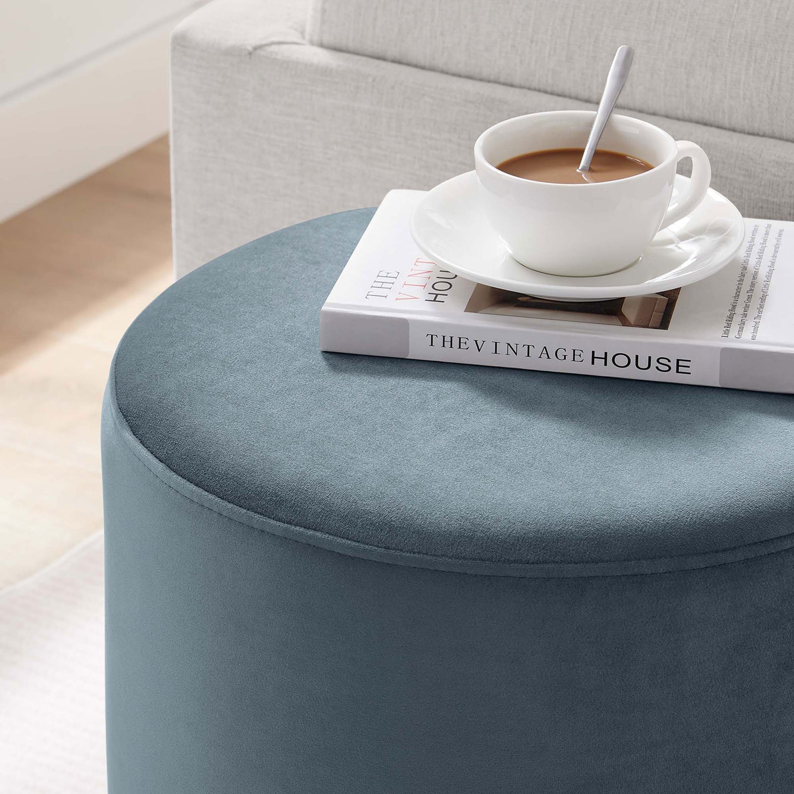 Blue velvet ottoman used as a chic side table beside a sofa || EEI-6652-CAB-NAT || detail_room
