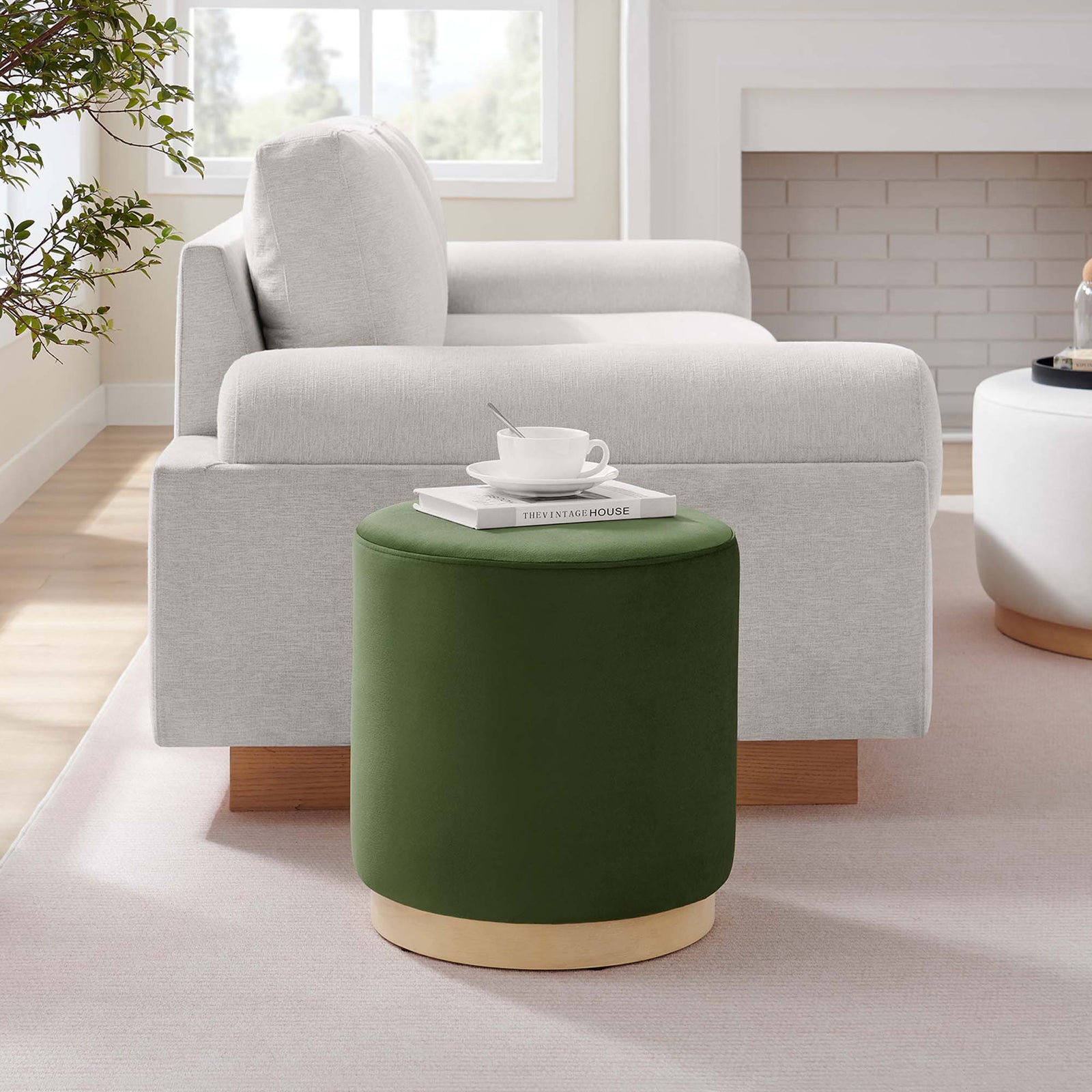 Moss green ottoman with natural wood base styled beside a sofa and coordinating white accent ottoman || EEI-6652-MOG-NAT || front_angle_series_room