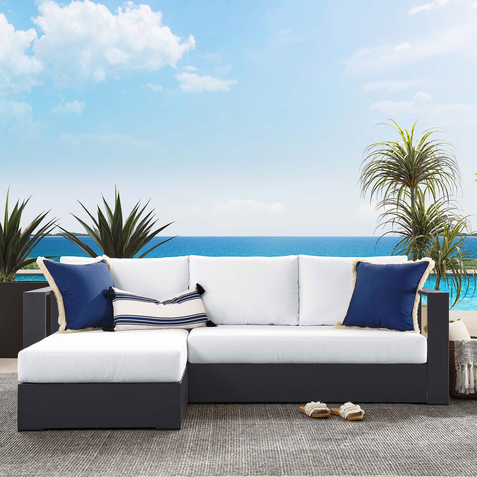 Left-chaise Tahoe sectional with bright white cushions styled on a coastal-inspired patio || EEI-6670-GRY-WHI || front_angle_room