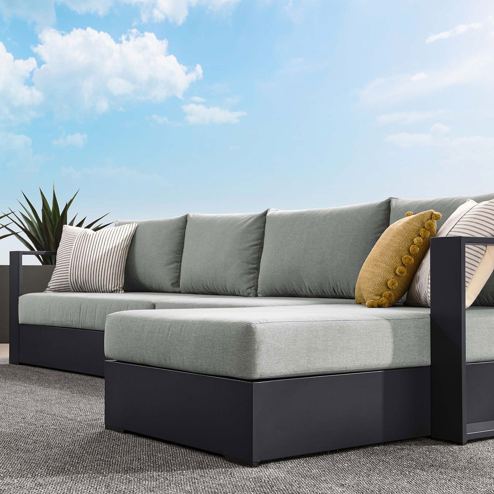 Right chaise sectional styled on a rooftop patio with ocean backdrop, mustard pillows, and cozy throw || EEI-6671-GRY-GRY || front_room