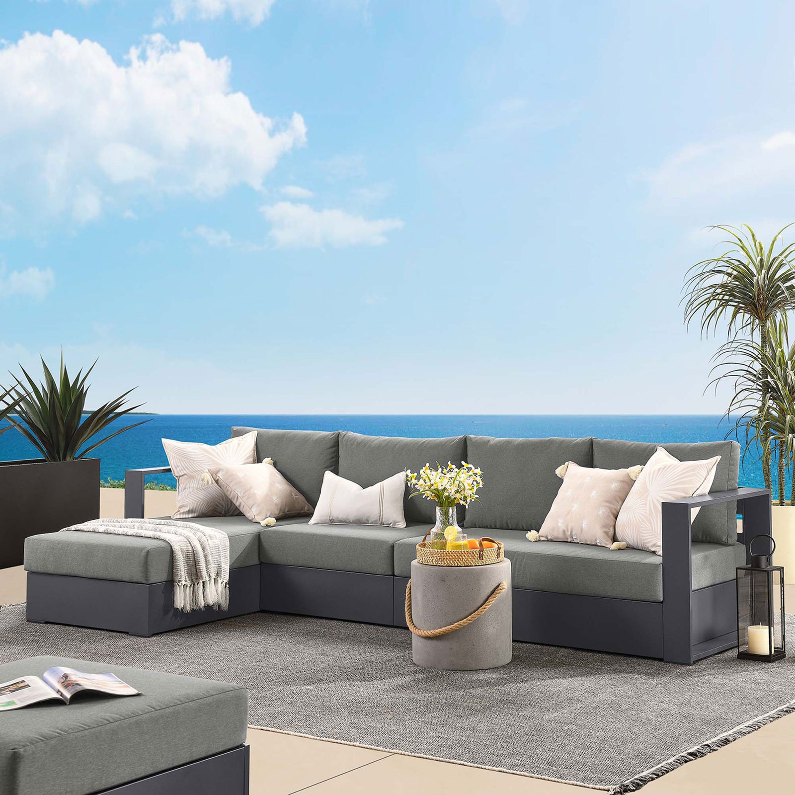 Left chaise sectional styled on a contemporary patio with ocean backdrop and soft neutral accent pillows || EEI-6672-GRY-CHA || front_angle_room