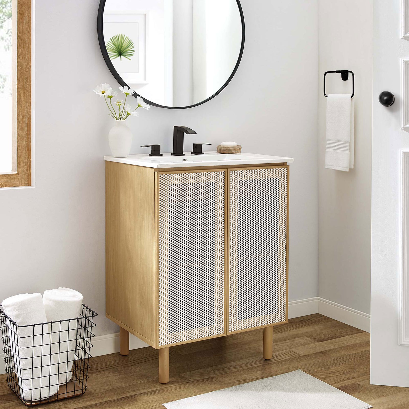 Modern vanity pairs warm oak grain with airy perforated doors and a bright ceramic sink. || EEI-6677-WHI-OAK || front_angle_room