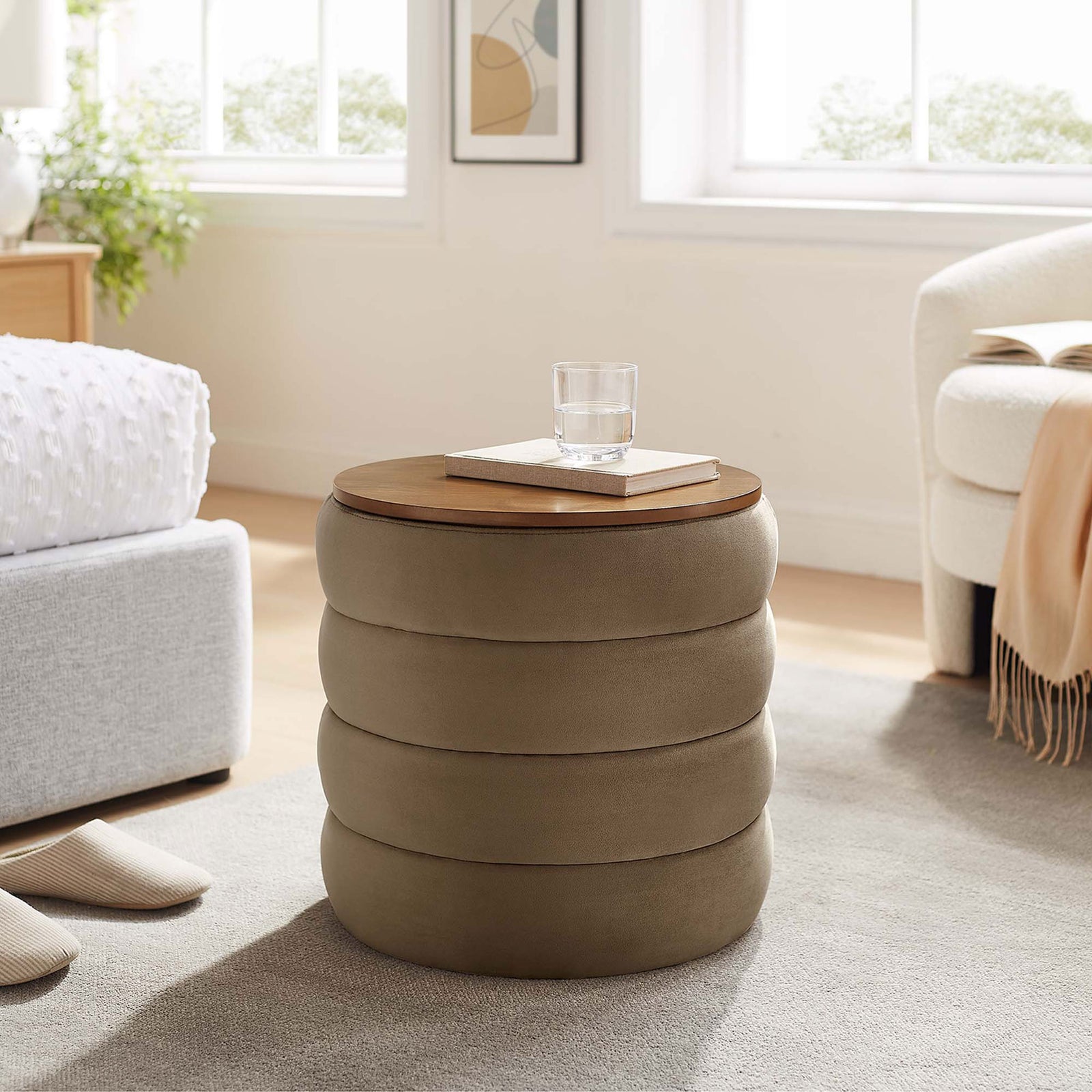Taupe velvet storage ottoman with wood top styled as a bedside accent table in airy bedroom || EEI-6684-TAU || front_angle_room