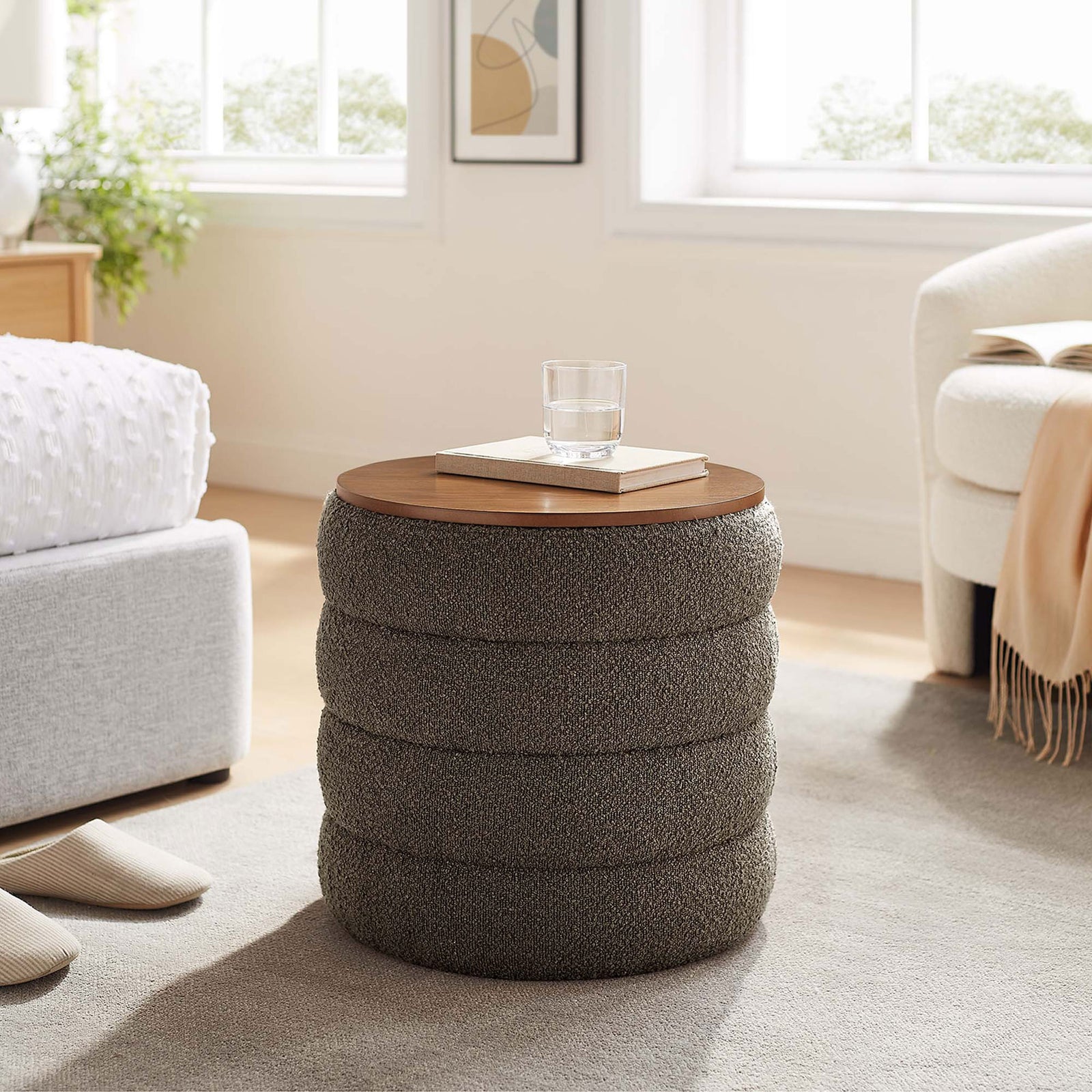 Pebble boucle storage ottoman styled as a side table beside a bed in a bright airy room || EEI-6685-PEB || front_angle_room