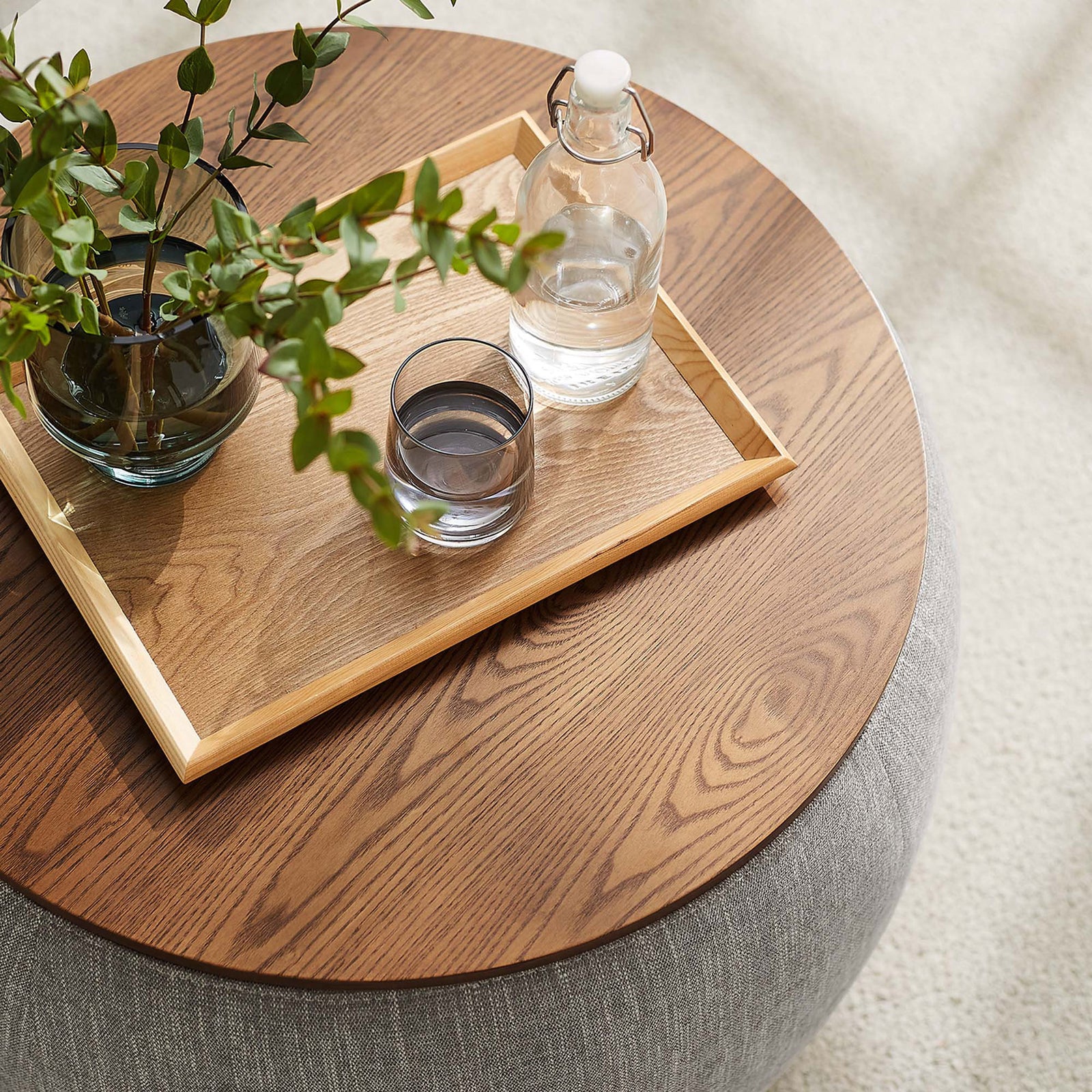 Styled wood top with tray, greenery, and glassware highlights the ottoman as a chic drink table || EEI-6688-HEW || detail_room