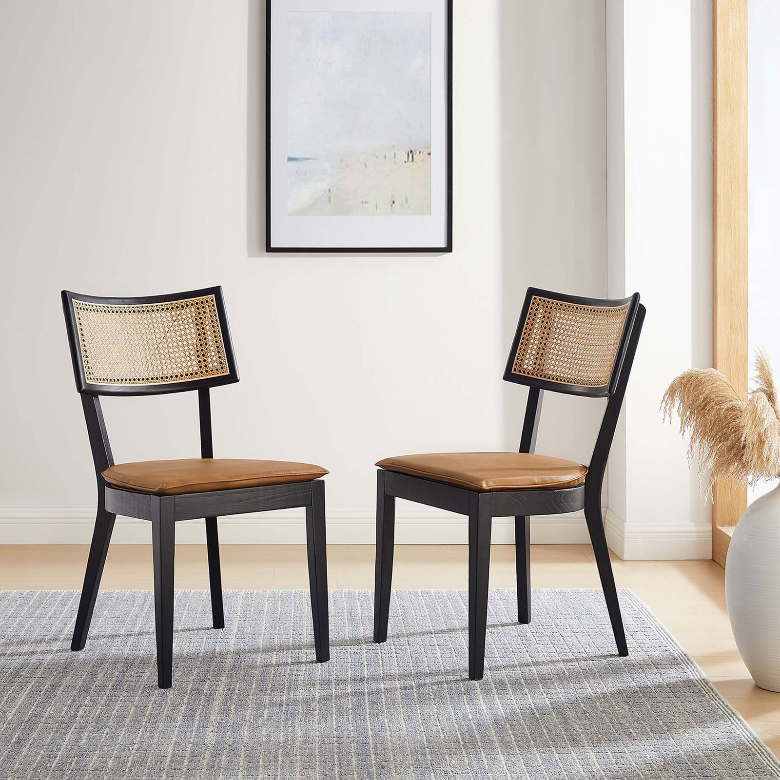 Set of two black wood dining chairs with tan vegan leather seats and rattan backs in a bright dining room || EEI-6732-BLK-TAN || front_angle_multi_room
