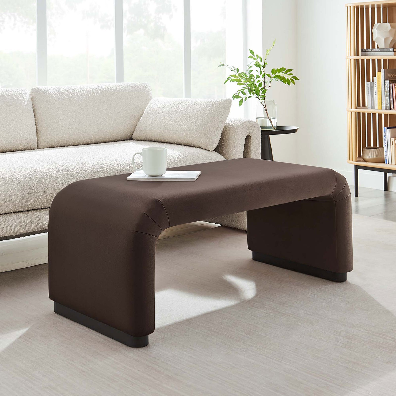 Sleek brown waterfall ottoman used as a coffee table in a bright minimalist living space || EEI-6735-BLK-CHB || front_angle_room