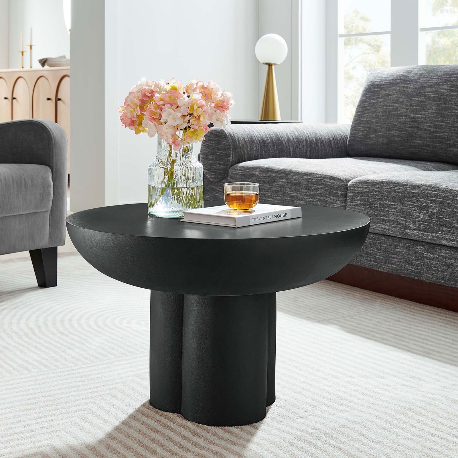 Statement black coffee table anchors the living room with modern, minimalist silhouette || EEI-6760-BLK || front_angle_room