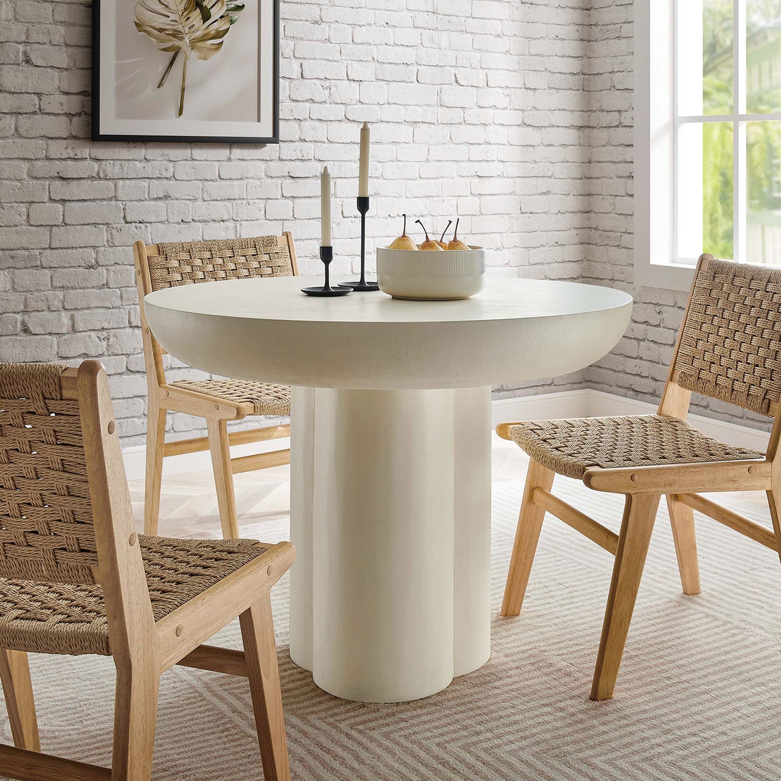 Caspian round dining table creating a warm gathering spot with woven natural chairs and a textured brick backdrop || EEI-6762-WHI || front_angle_room