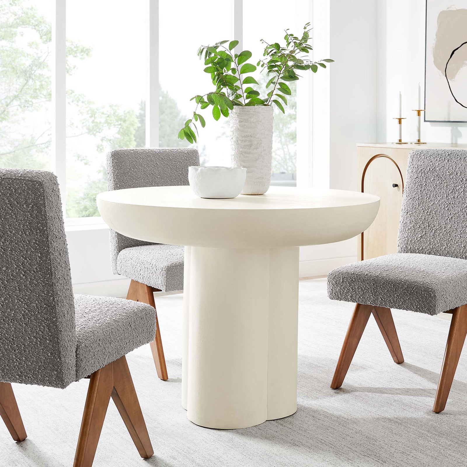 Modern white round pedestal dining table paired with plush gray chairs in a light-filled contemporary dining room || EEI-6762-WHI || front_angle_room