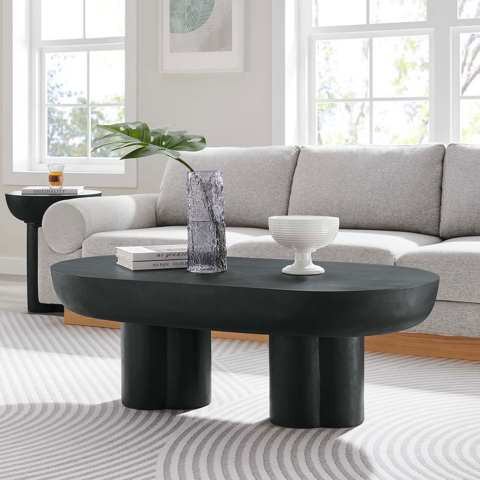Modern centerpiece anchoring the lounge with sculptural pedestals and a spacious oval surface || EEI-6763-BLK || front_angle_room