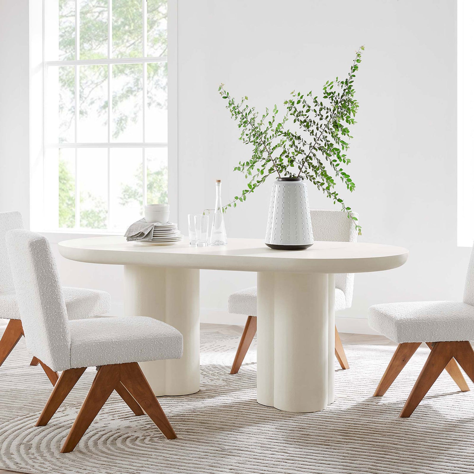 Caspian white oval dining table in a bright modern dining room with plush accent chairs || EEI-6764-WHI || front_angle_room