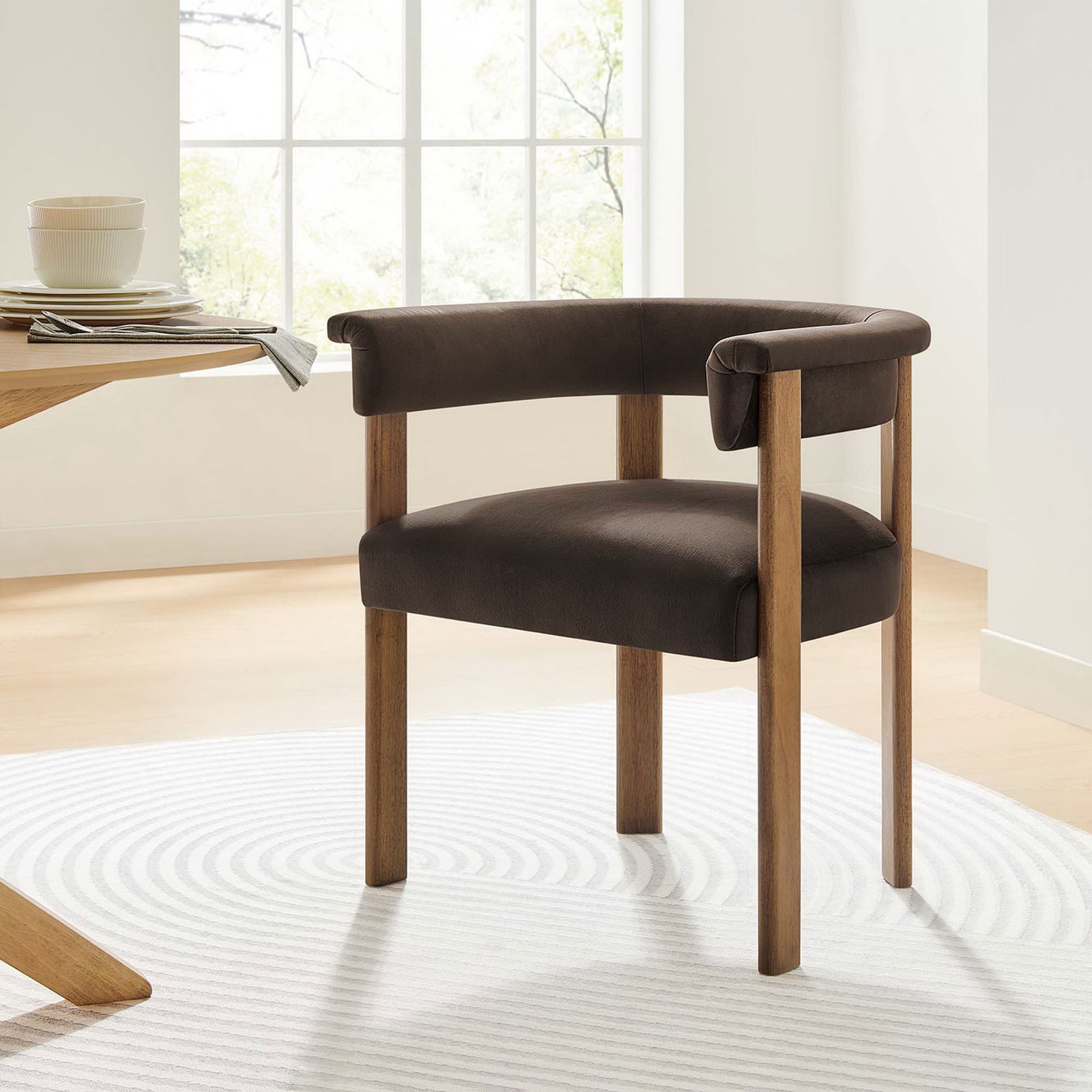 Chocolate brown velvet barrel dining chair styled at a light wood dining table in a bright room || EEI-6775-CHB-DBR || front_angle_room