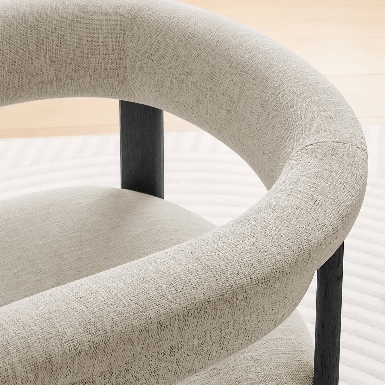 Heathered ivory upholstery and barrel back silhouette add soft texture to this chair in a bright room || EEI-6776-HEI-BLK || detail_room