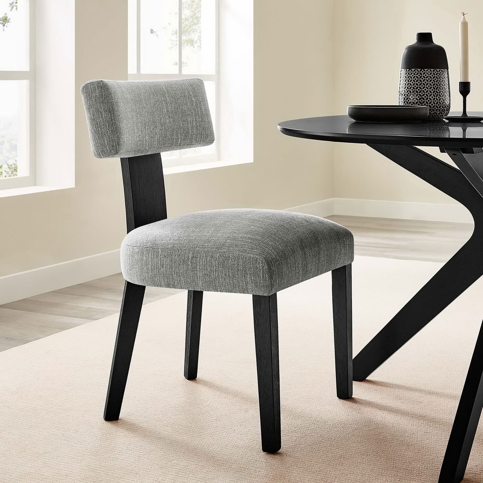 Gray upholstered dining chair brings modern style to a bright dining space with black table accents || EEI-6777-HEG-BLK || front_angle_room